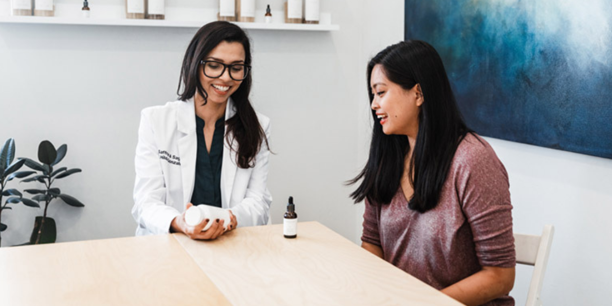 Doctor in a white coat talking with a patient at Saffron & Sage in San Diego