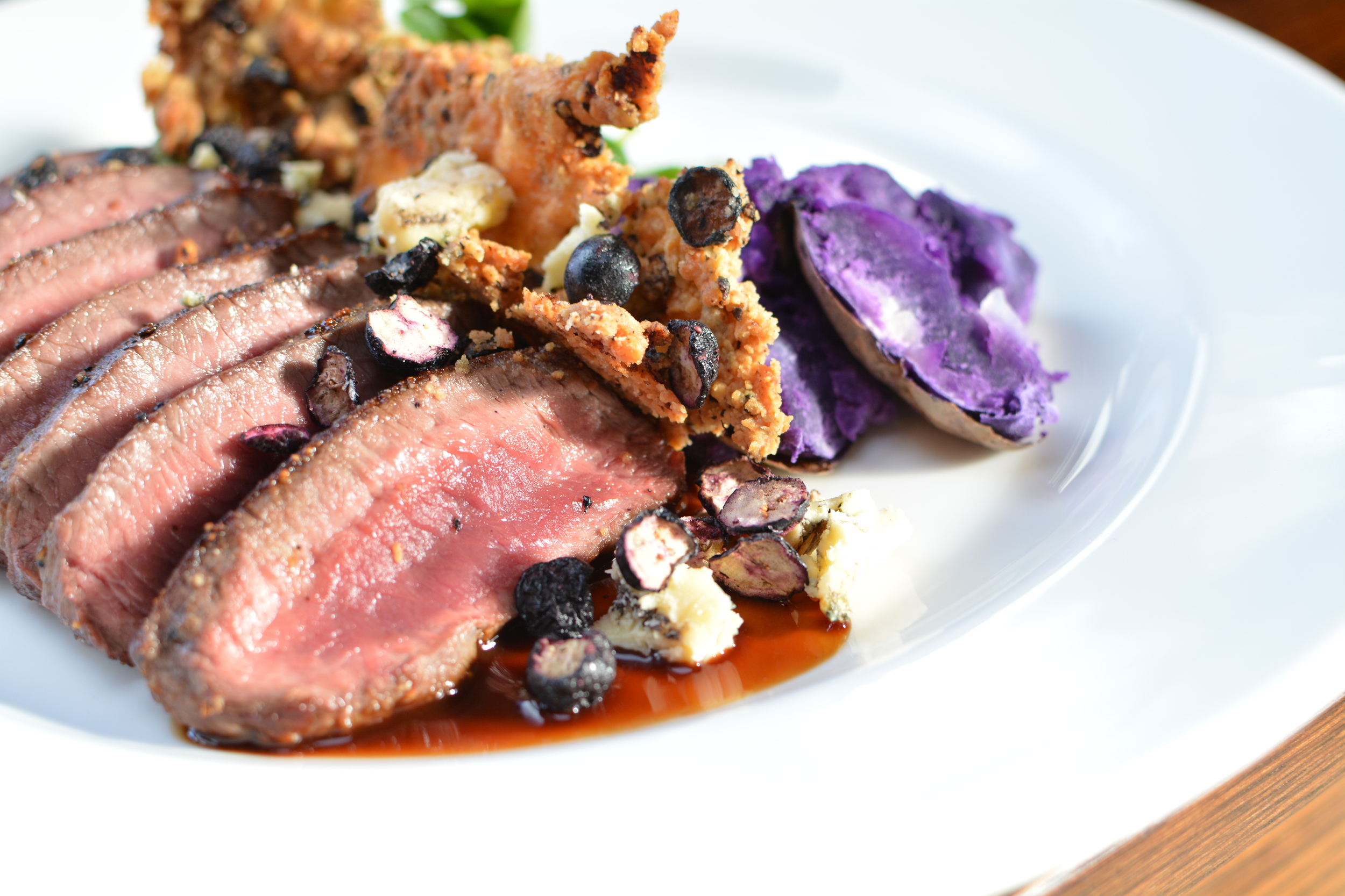 Char Seared Venison Loin w/ Blueberry Cheese Crumble dressed with Fresh-As Blue Berry slices and Maori potatoes