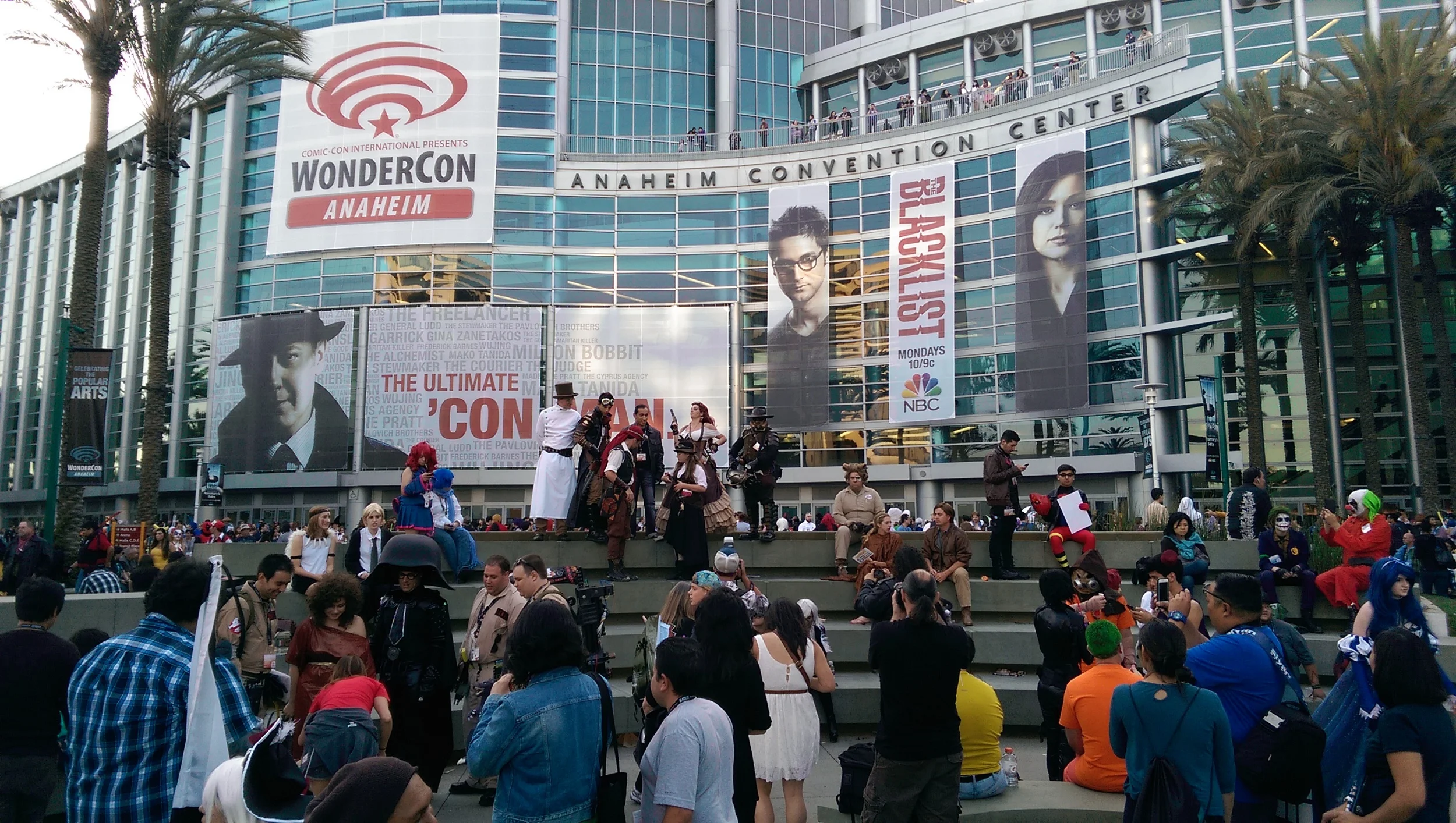 Cosplayers, attendees, and passerbys mingling outside the convention center during WonderCon