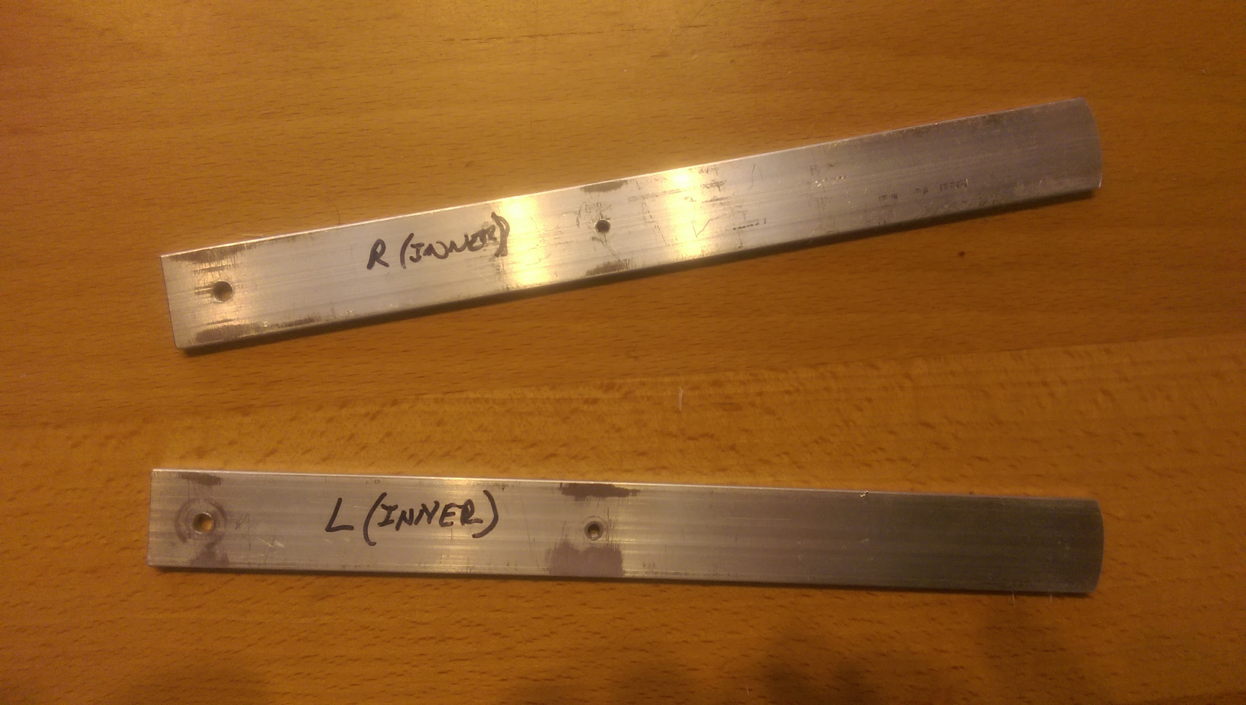 The lever arms cut to size, a clearance hole at one end and a threaded hole for the thrust rod attachment