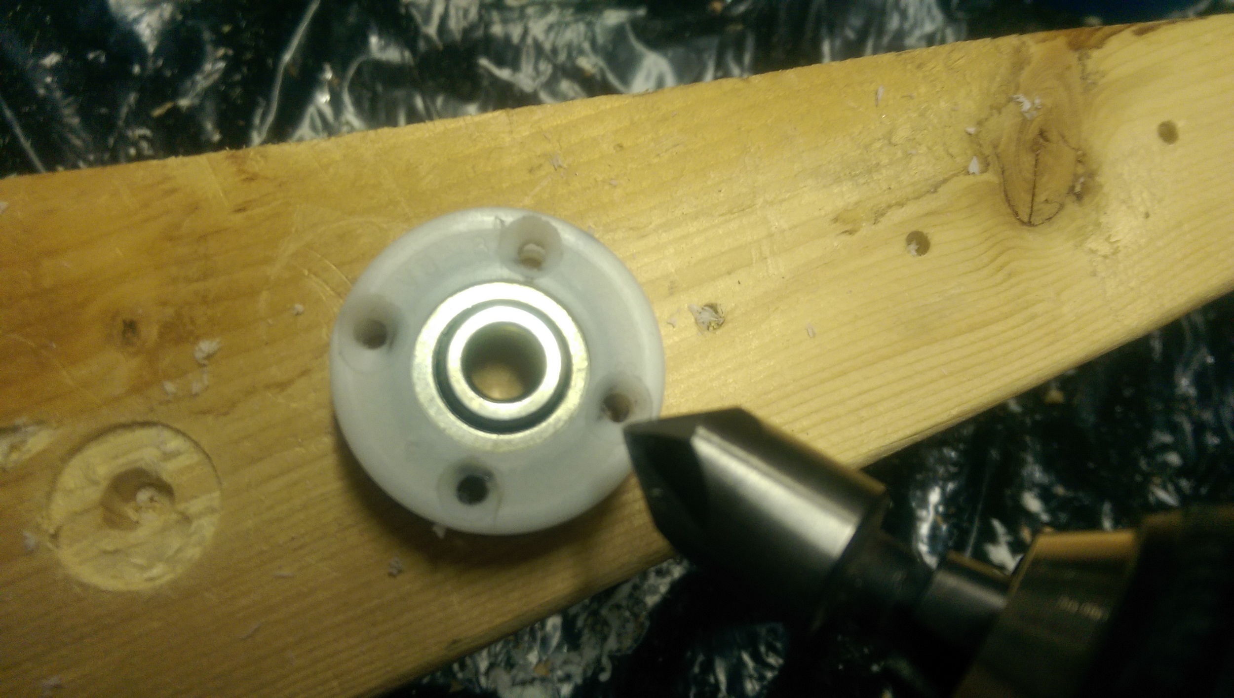 Drill and countersink the outer ring which will screw into the larger end cap