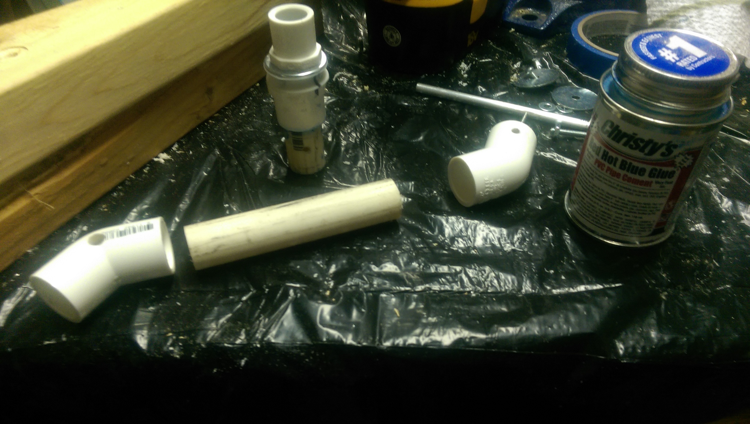 A short section of PVC was glued to the large end cap of the new joint. Next, the pieces of the neck are laid out to be glues