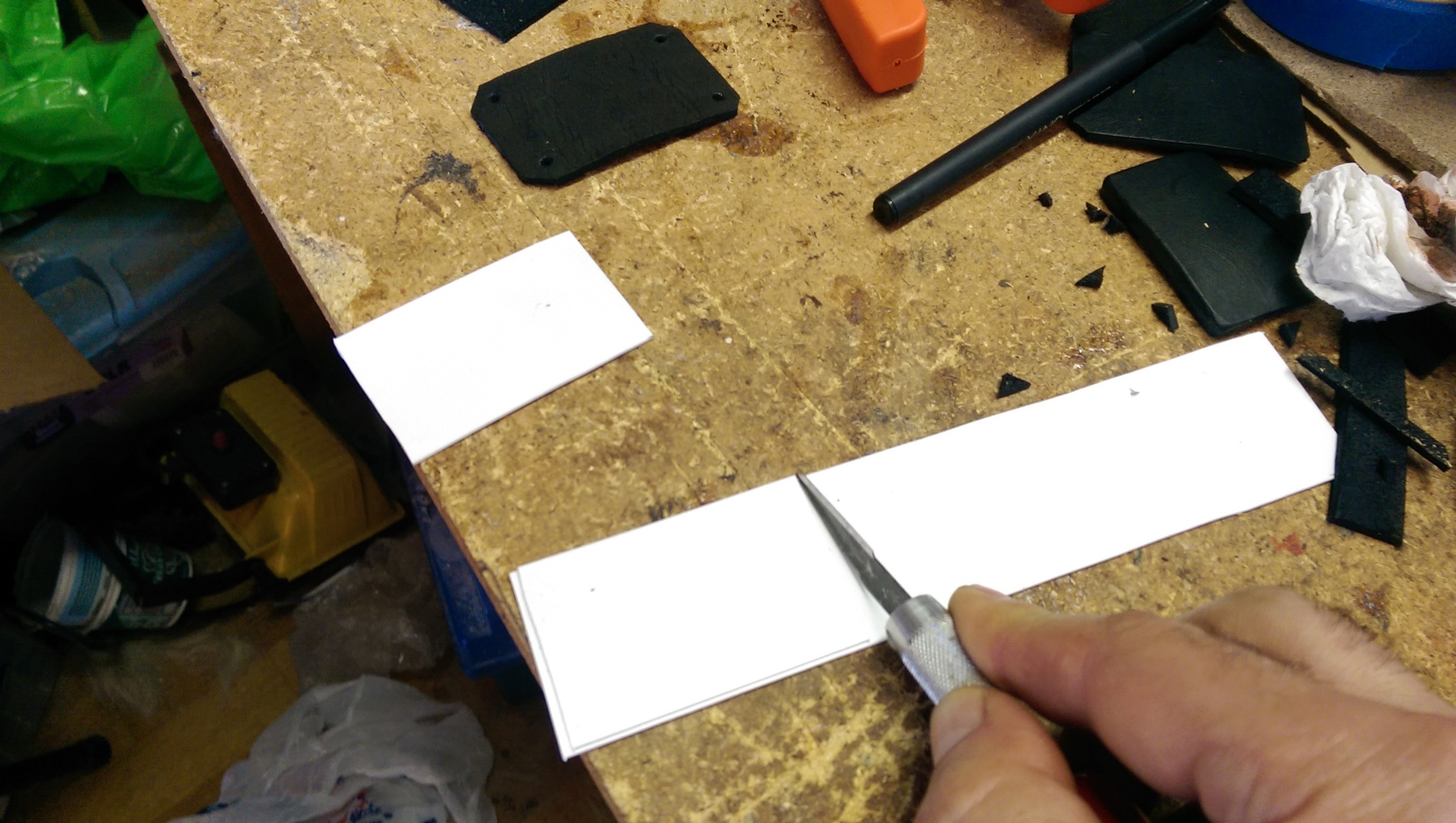 Pieces of thin styrene cut smaller than the leather