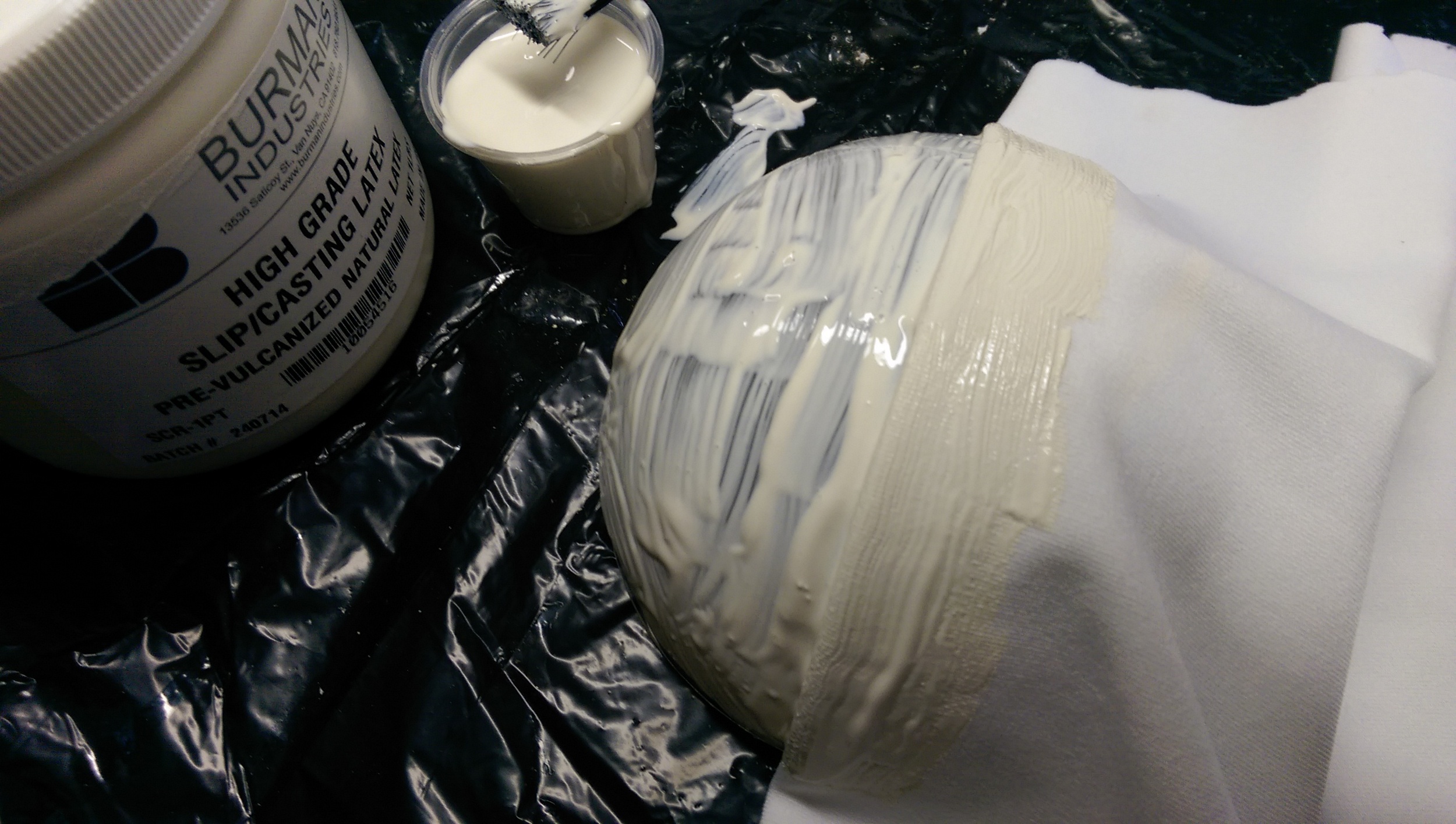 The spandex is folded, placed into the silicone, and then more of the silicone is brushed on
