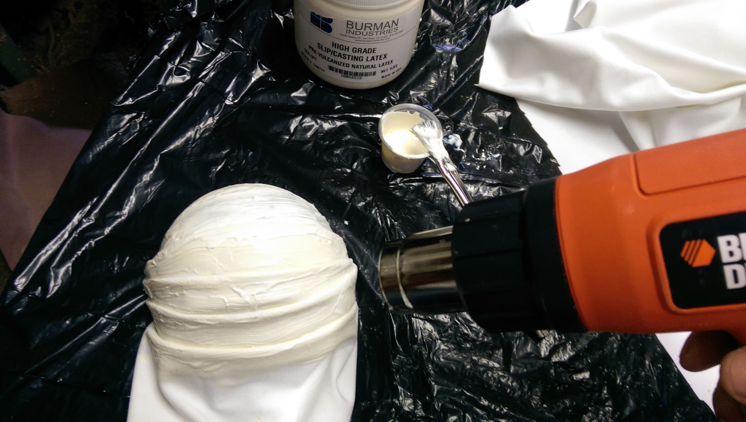The spandex is folded into a series of wrinkles, and each layer is brushed with silicone. After all is applied, I've gently sped up the drying using a heat gun.