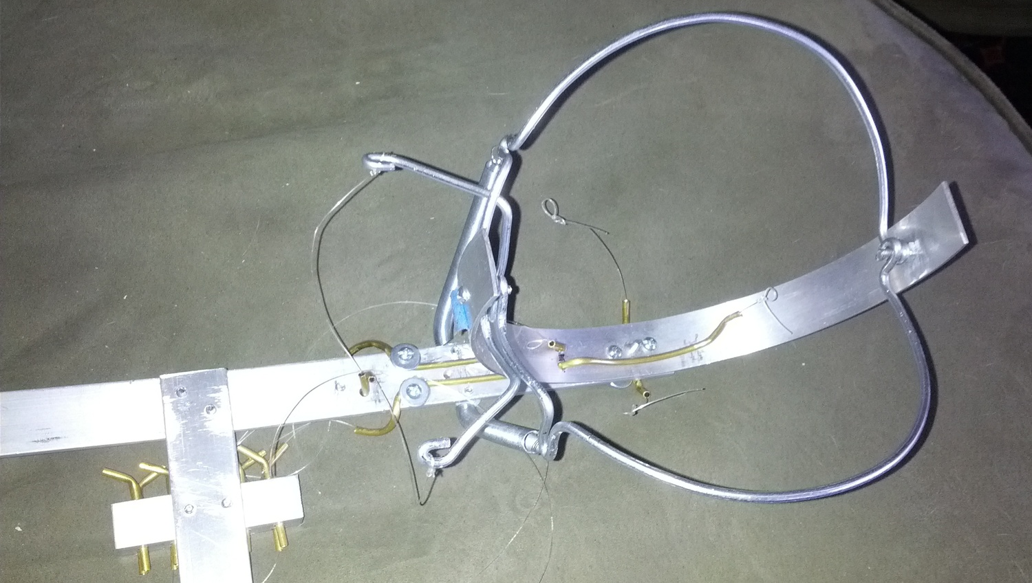 Another early mechanism had crossed lever arms with springs. The fishing lines with loops retracted the eyelid. This design had too many points of interference.