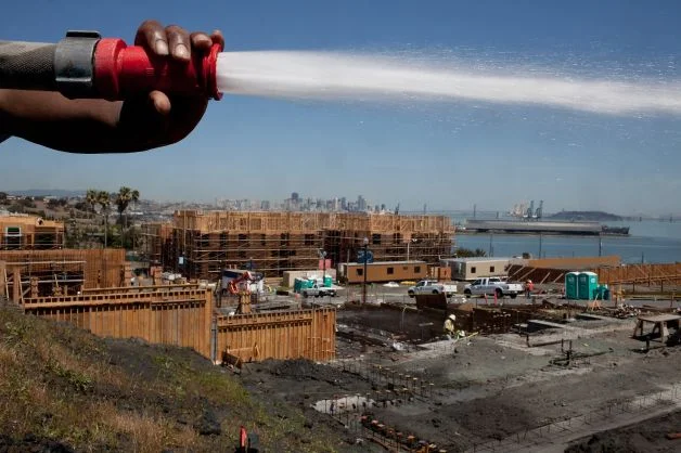 Michael Brown sprays down the land at the Shipyard, the new development at Hunters Point in San Francisco. Photo: Tim Hussin, Special To The Chronicle