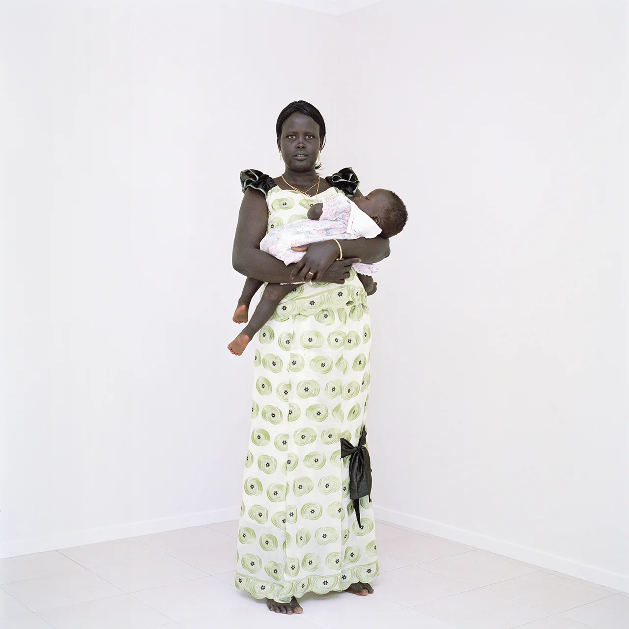 I started working on this project about the Sudanese diaspora in Australia after photographing a family for another project set in the suburbs. According to figures from the Australian Bureau of Statistics, the Sudanese community is currently one of the fastest growing groups in Australia. In the last few years many Sudanese migrants have moved into the area where I live and I’ve watched their integration into our (largely Anglo) community with interest. After making my first portrait of a family who’d been in Australia for 4 years, I suddenly had many other families asking me to make portraits of them too. Throughout the process of photographing, I heard many stories as to how and why they’d arrived here. As a mother with my own family, I find it impossible not to be moved. Stories of immense courage and sacrifice but also of hope, for a brighter future in Australia. Australia is a country that maintains a controversial record for embracing migrants; government policies are parochial at best and there remains an underlying racist tension which is deeply rooted in a traumatic and unacknowledged indigenous history. And so, I wonder how this community will settle and maintain a sense of their own identity? How will they integrate and contribute to the cultural future of Australia? As I negotiate my engagement with the community, my aim with this project is to continue working on the series of portraits but to also evolve it into a larger body about identity, displacement and belonging as well as the process of integration and citizenship in the context of the Australian suburbs. In making this portrait of my new neighbours, I hope to find some measure of understanding that transcends culture and language and that I can share with my fellow Australians for the present and into the future.