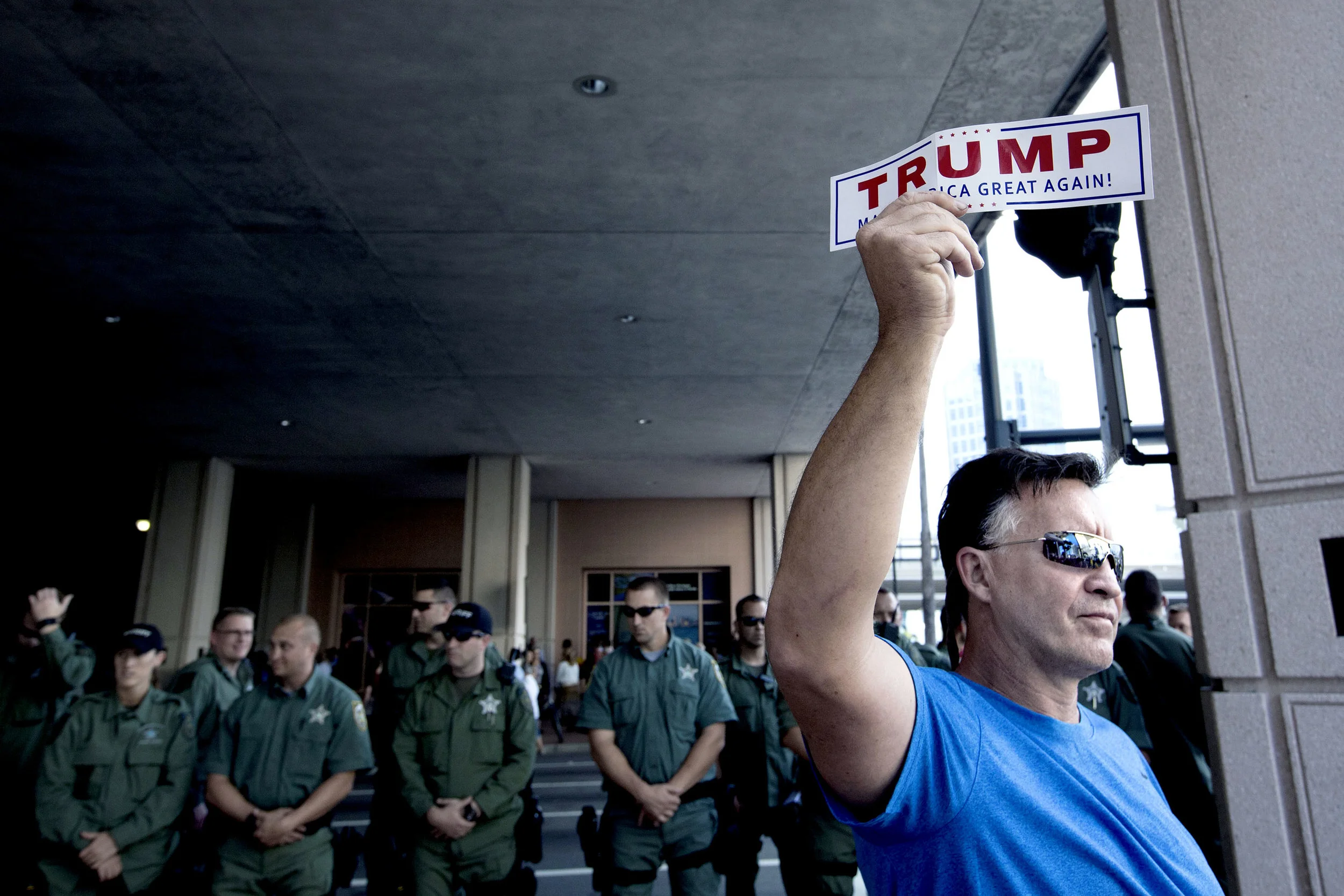En Trump-supporter utanför Tampa Convention Center där Donald Trump höll ett valmöte dagen före primärvalet i Florida. Många poliser var även på plats i fall det skulle bli bråk mellan anti Trump-demonstranter och hans supportrar.