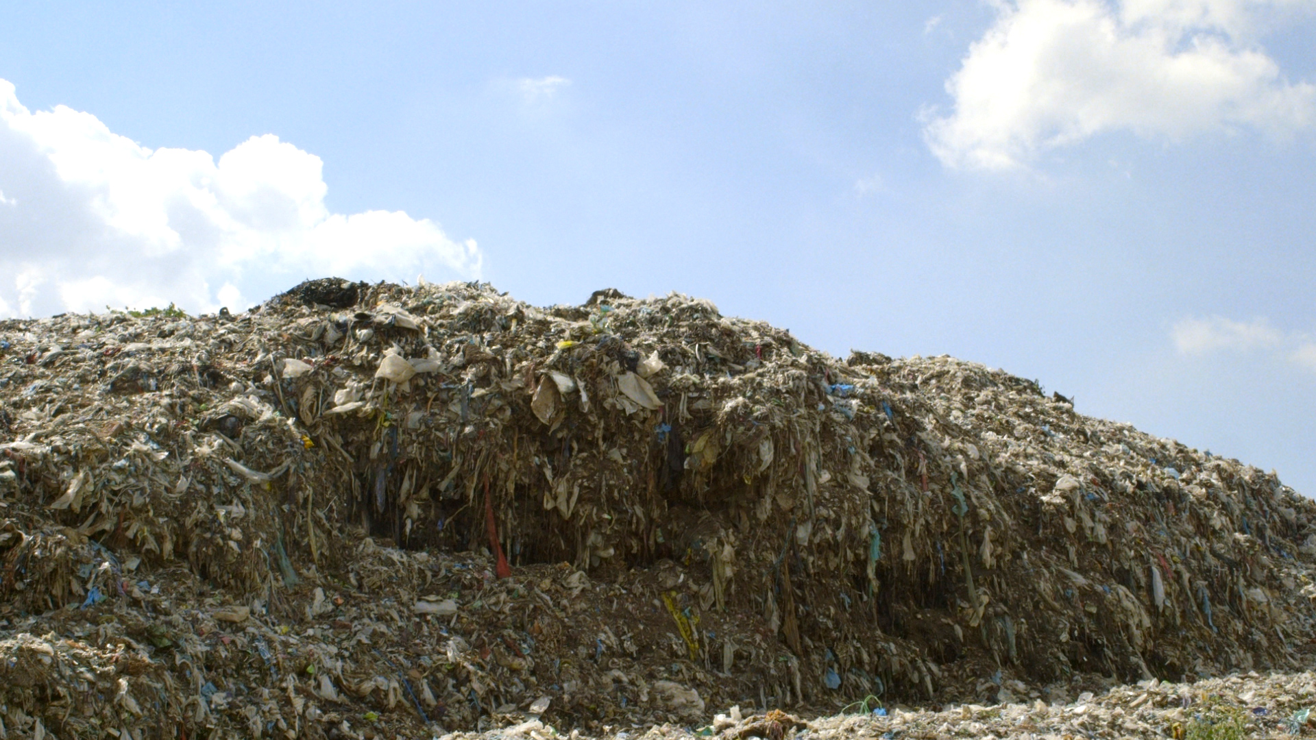 Piles of discarded textiles and old clothing. Source: The True Cost