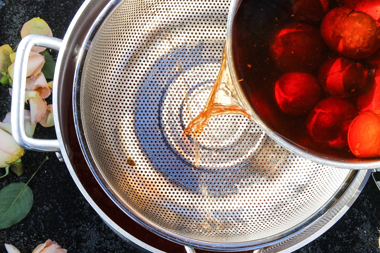 Ruby red dye extract being strained into the large dye bath.