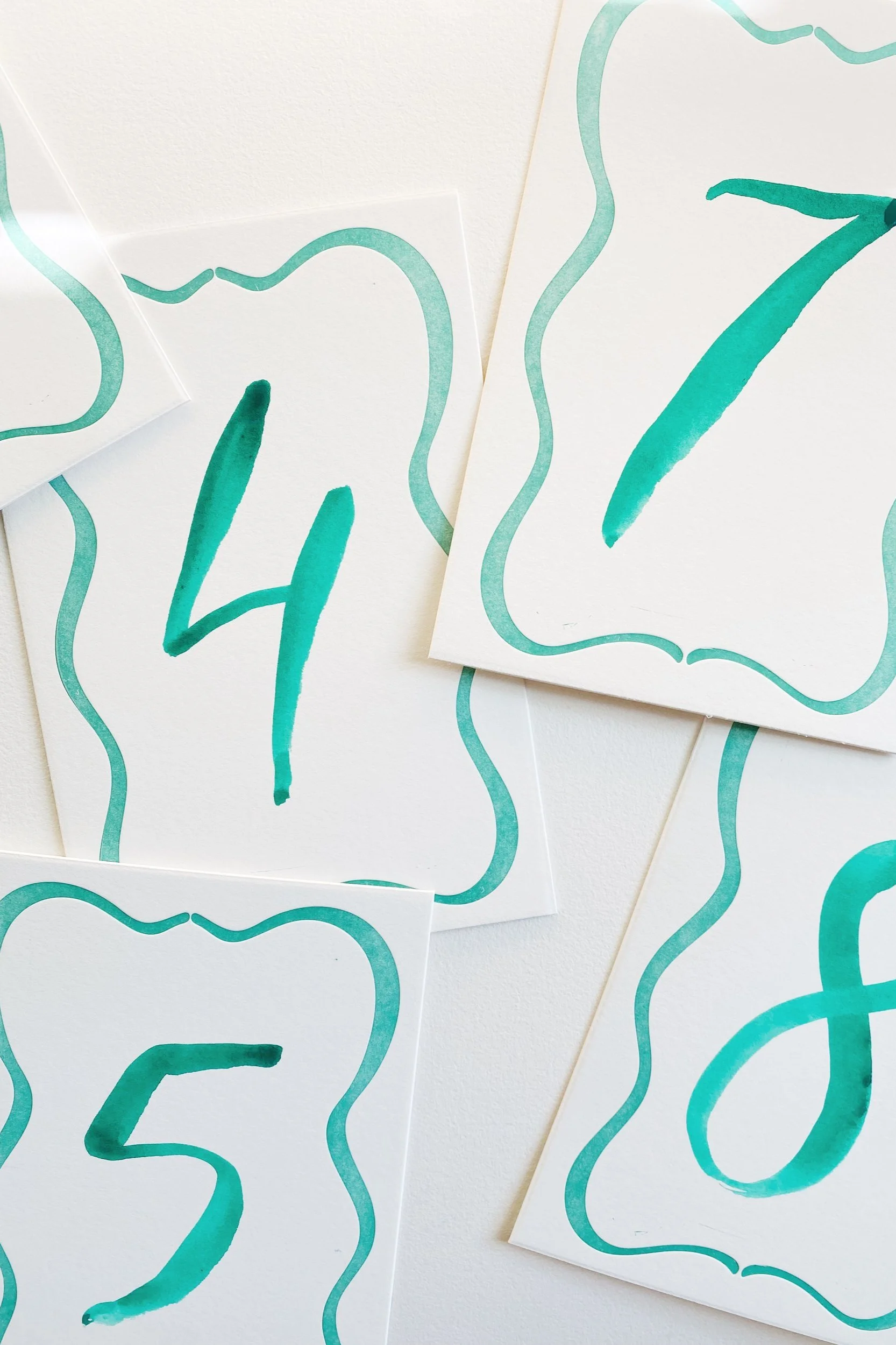 watercolor+brush+lettered+table+number+with+letterpress+squiggle+border.jpg