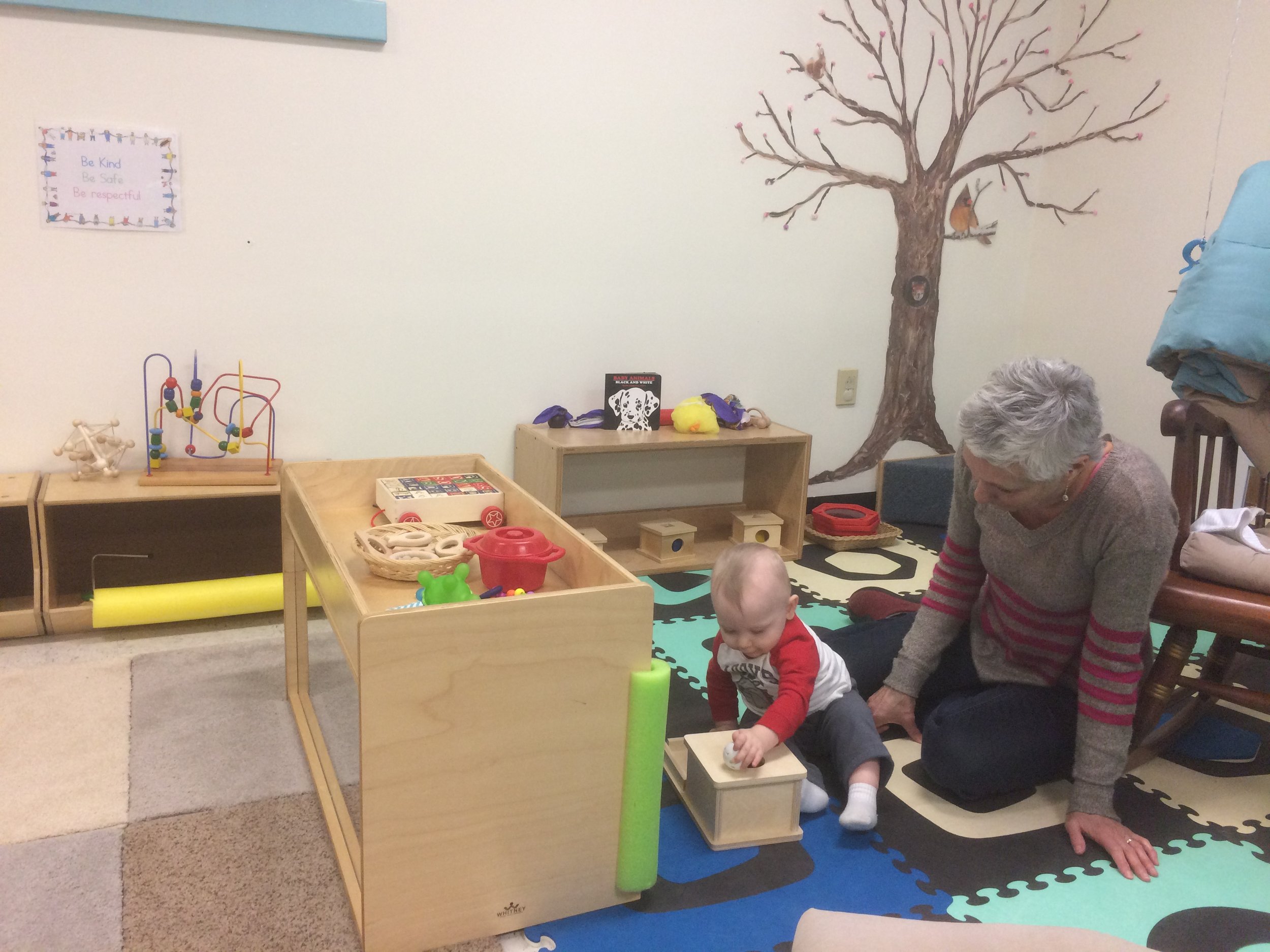 Montessori Toddler student working on the knobbed cylinder block activity. The purpose of this activity is to help develop the child’s visual perception of dimension and coordination of movement, as well as strengthen the child's fingers for writing.