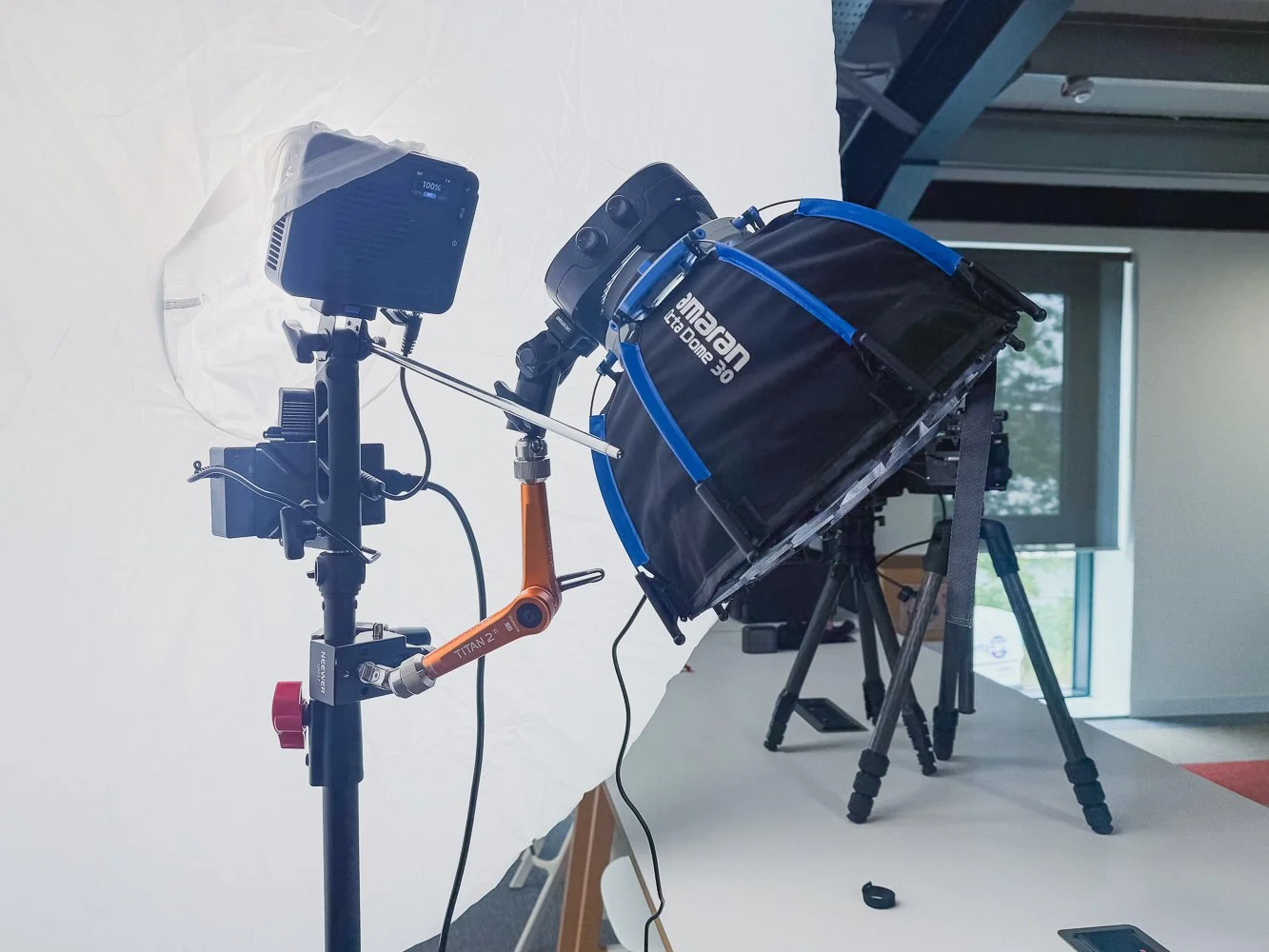 Bright Tangerine Titan Arm 2 Ti mounted to light stand holding a light