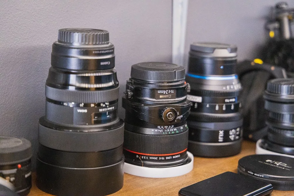 A series of camera lenses on a shelf
