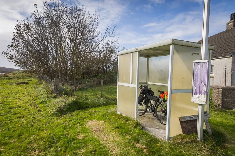 A bike in a bus stop sheltering from rain on the Hebridean Way
