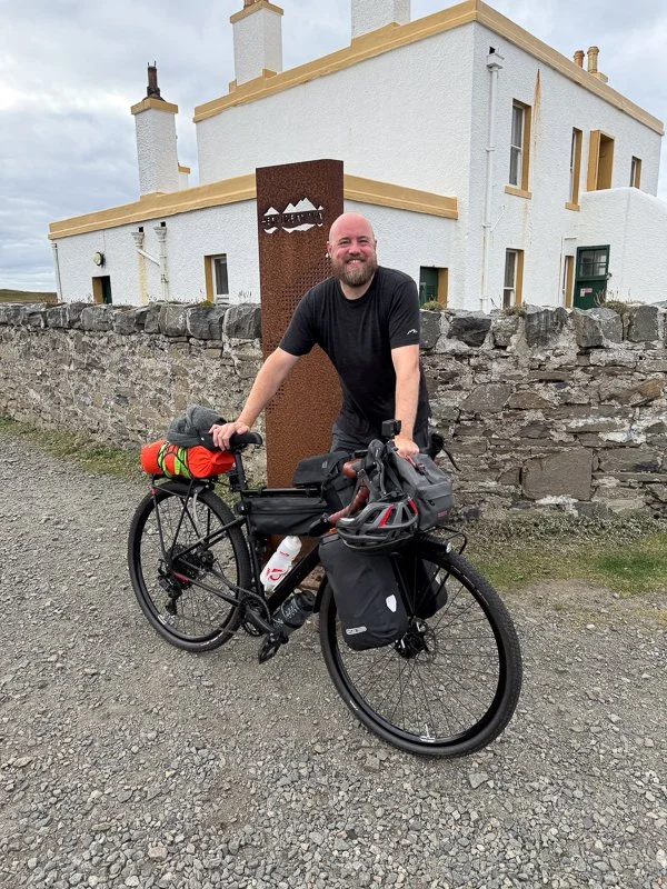 A bikepacker at the end of the Hebridean Way cycling route