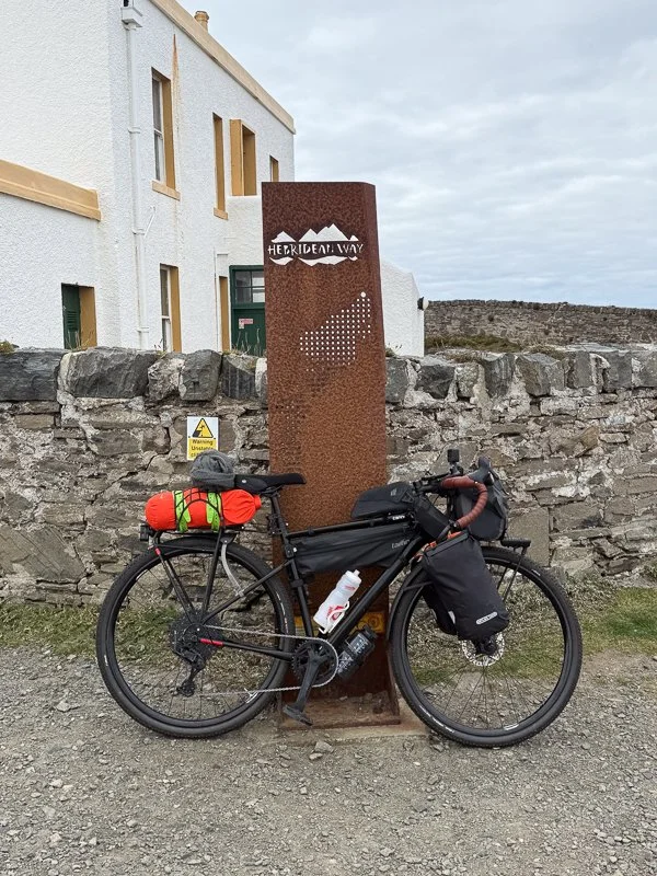 A bikepacker at the end of the Hebridean Way cycling route