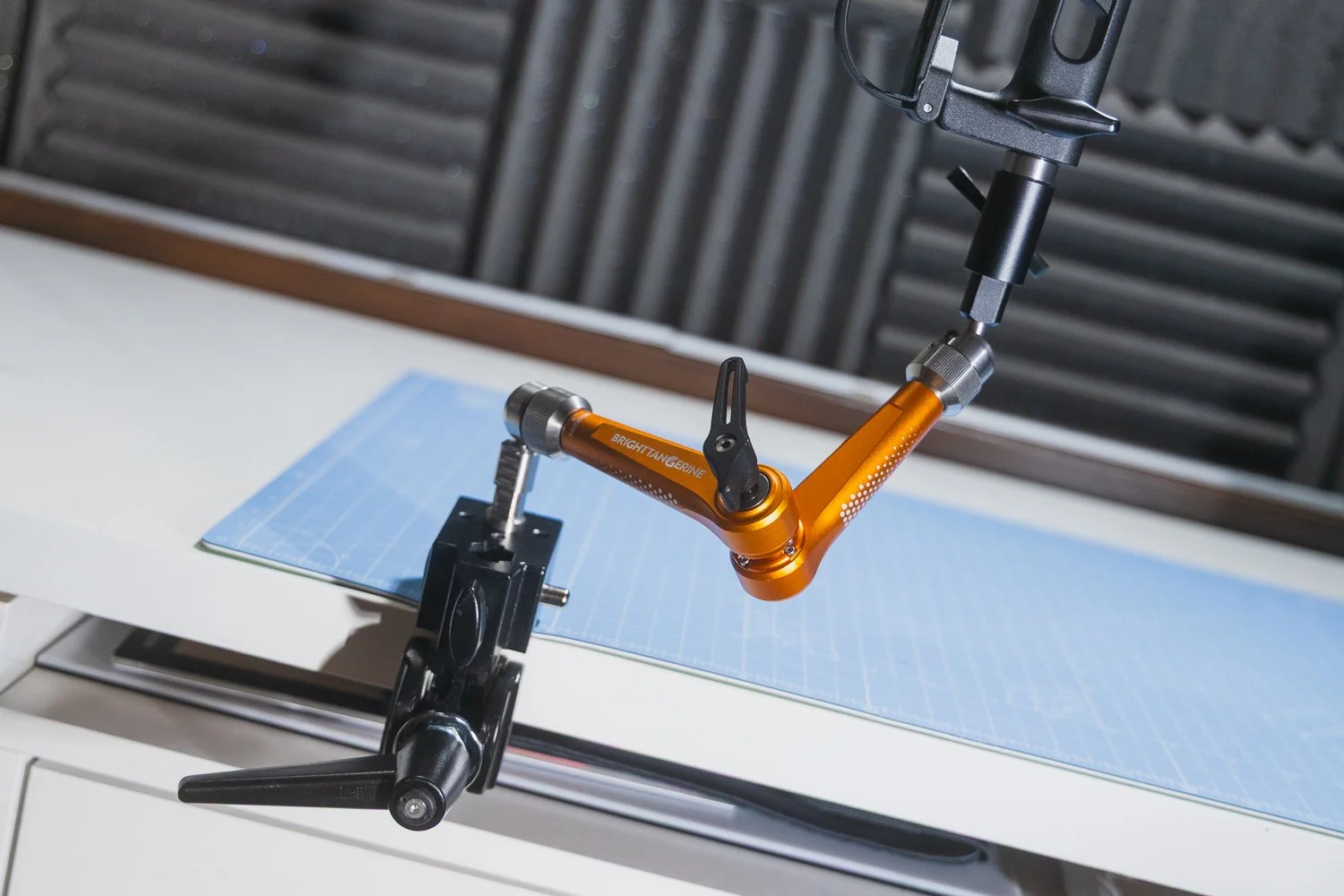 Bright Tangerine Titan Arm 2 Ti attached to a desk