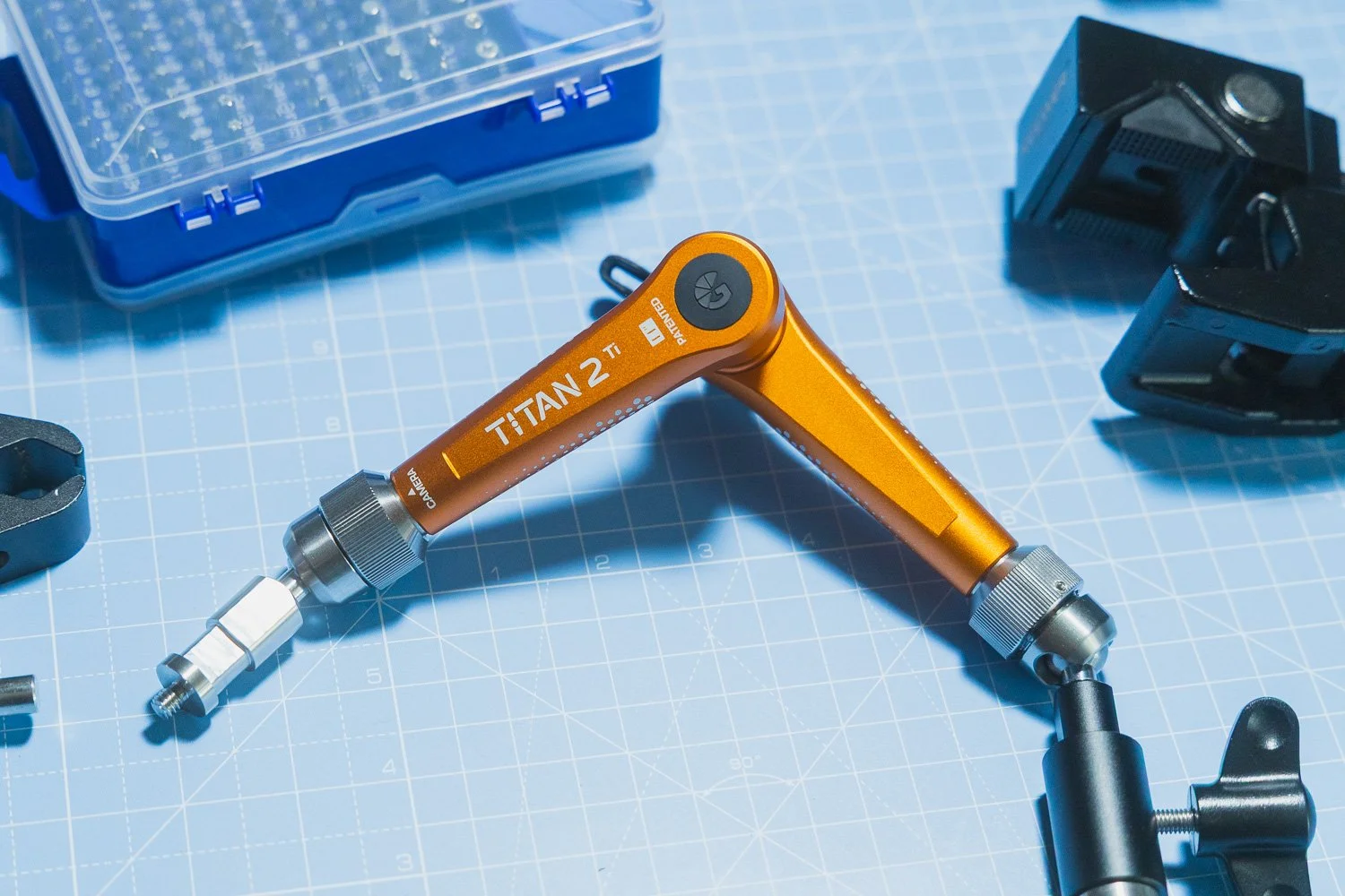 Bright Tangerine Titan Arm 2 Ti angled on blue background with accessories