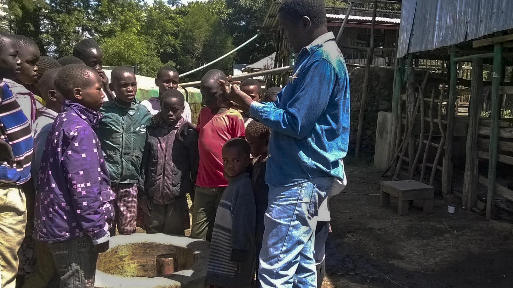 Josphat explains the biogas digester to students from the Youth Training Programme (YTP)