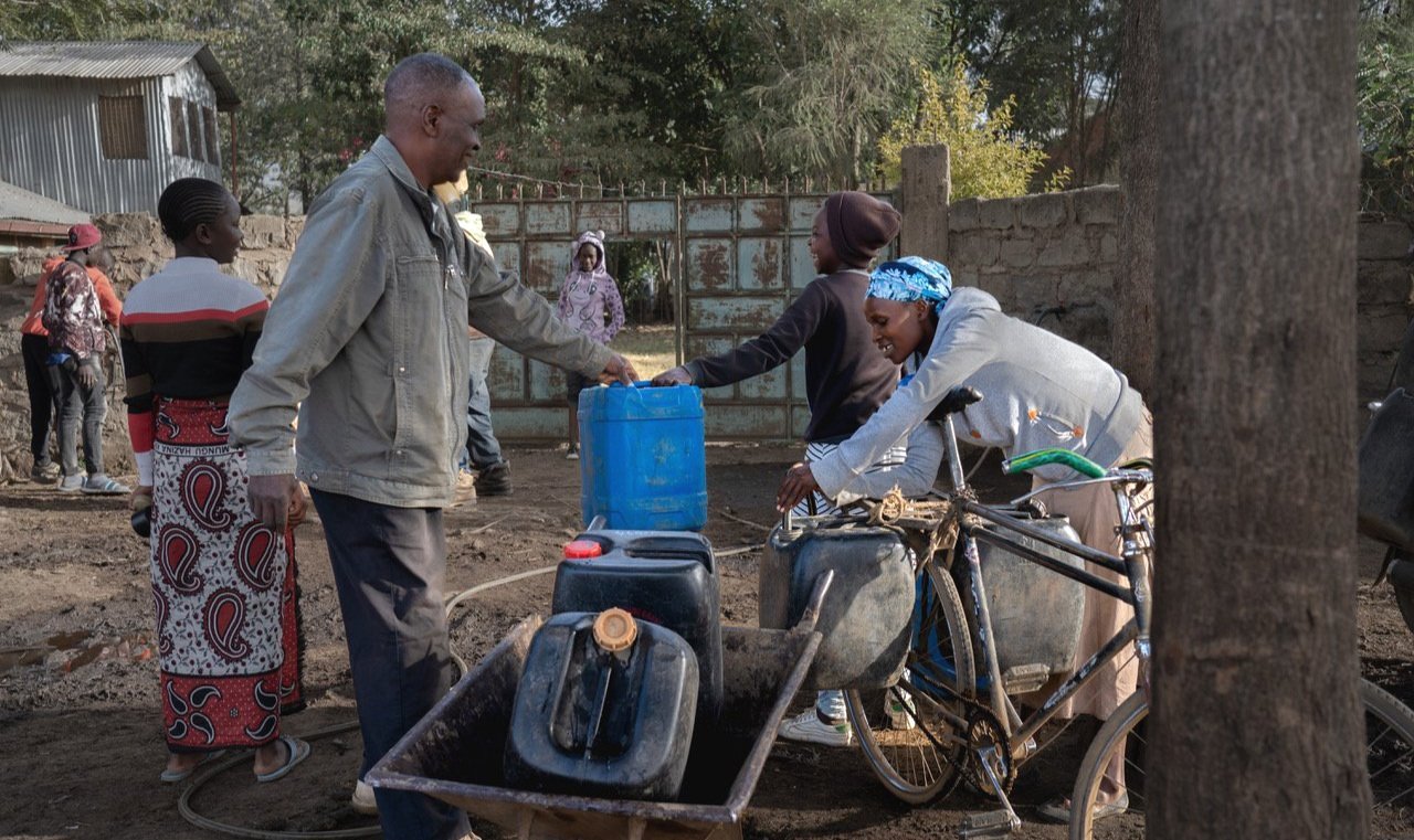 Villagers fill their jerrycans with well water