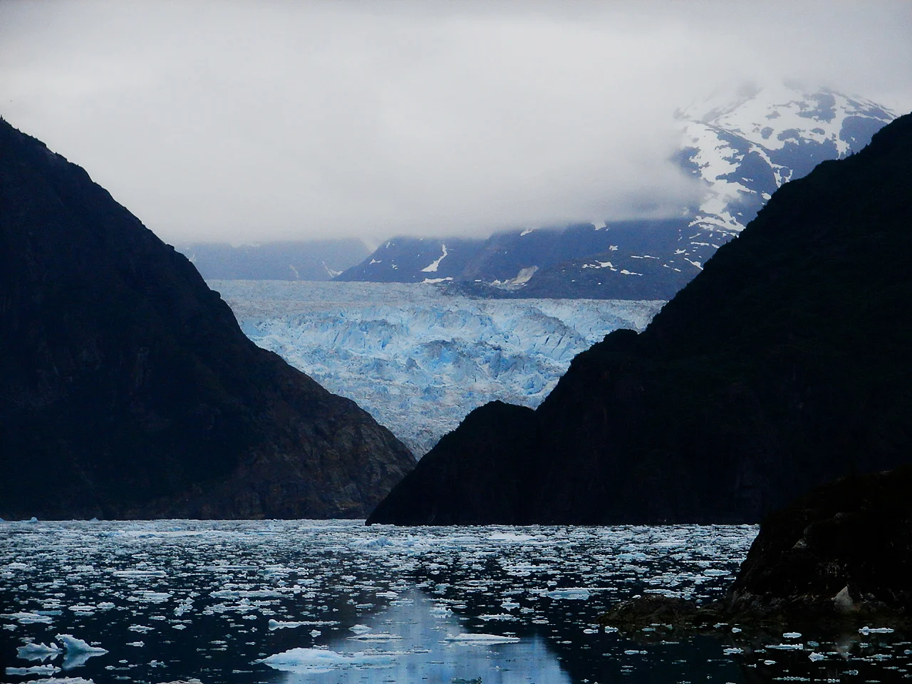 A glacier peaks out just beyond, and ice floats down in the crystal clear water--undisturbed. Location: Inside passage, Alaska, USA Photo by Trey Takahashi