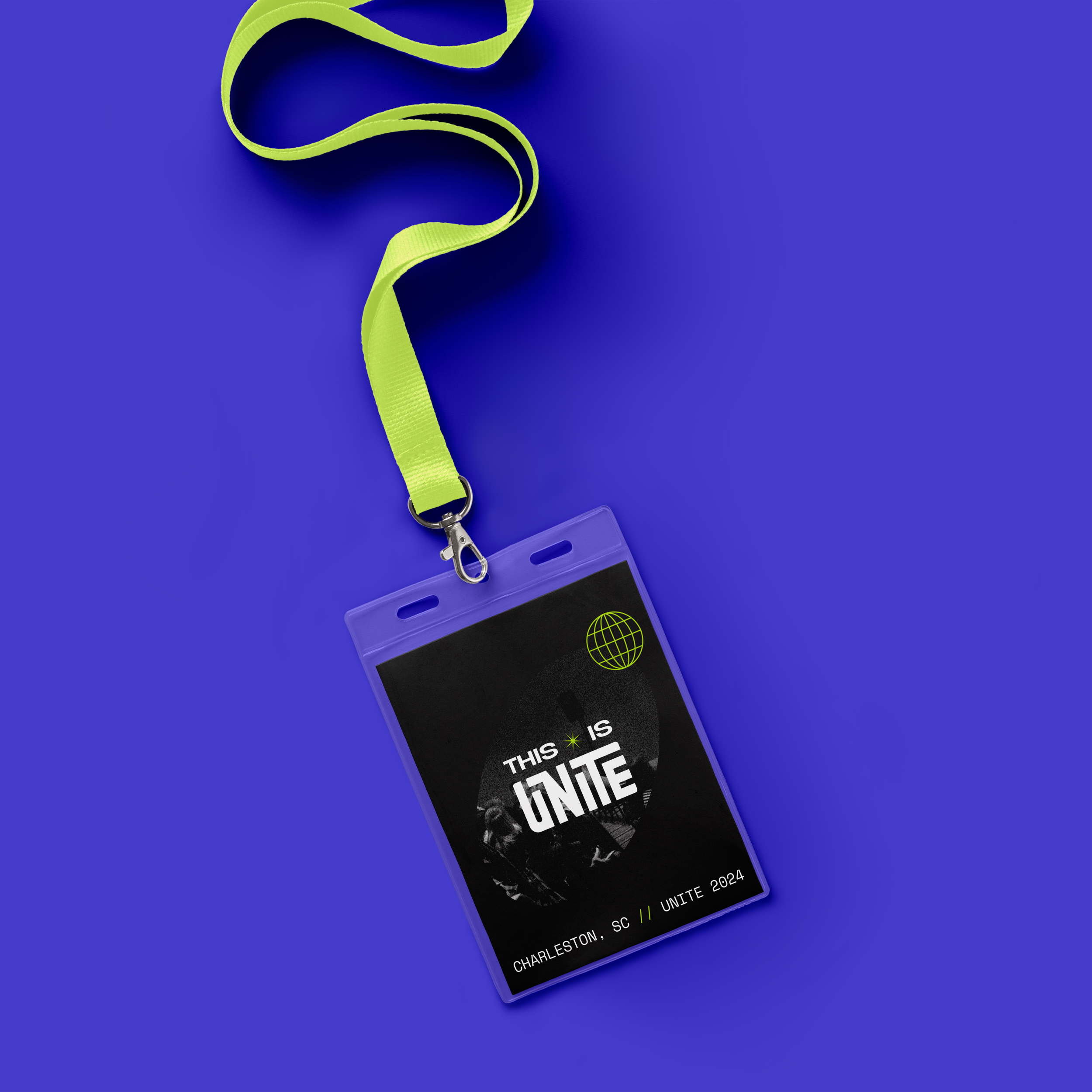 A neon green lanyard with a badge holder attached, displaying a black badge with white text and a green globe icon, set against a blue background, promoting an event in Charleston, SC in 2024.