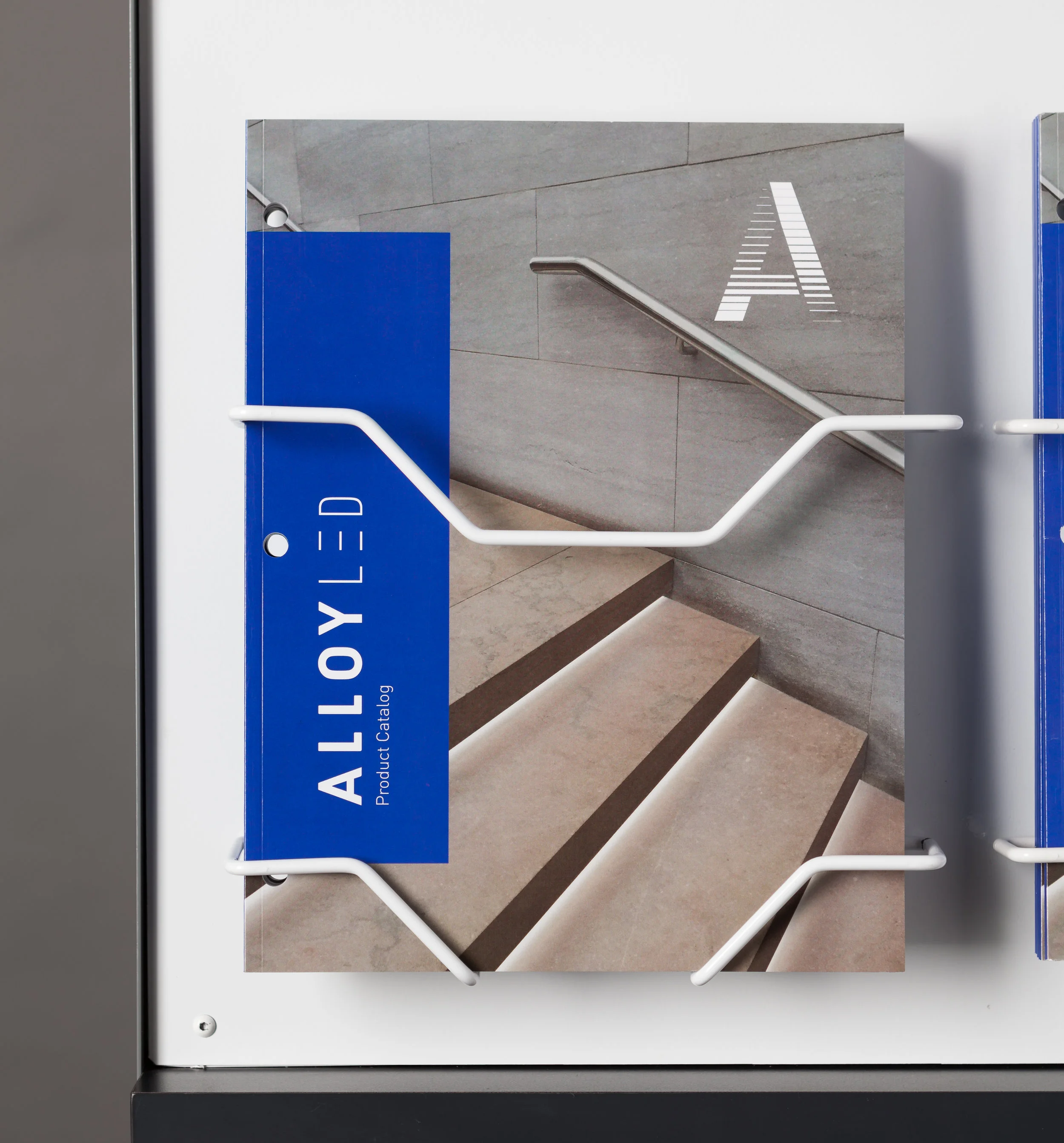 The custom wire brochure holder is modular to the display and also compatible with slat wall and peg wall environments.