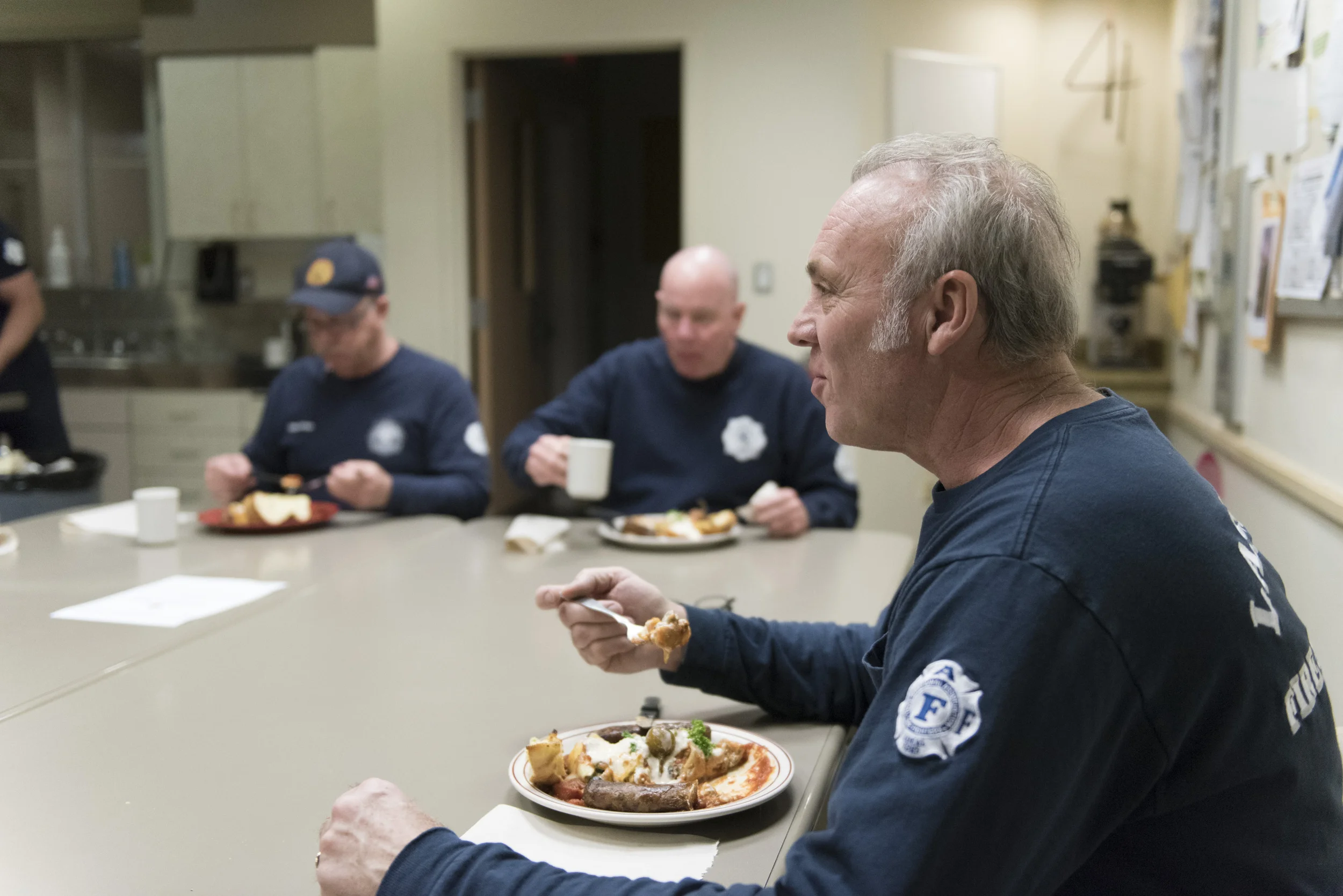 From right, Firefighter Ted Ramey, Firefighter Tom Thomas and Captain Mickey Pedrol eat dinner at Las Vegas Fire & Rescue's Fire Station 41 in Las Vegas Monday, Jan. 11, 2016. The dinner consists of Italian stuffed shells, grilled sausage, garlic bread, green salad and banana cream pie. Jason Ogulnik/Las Vegas Review-Journal
