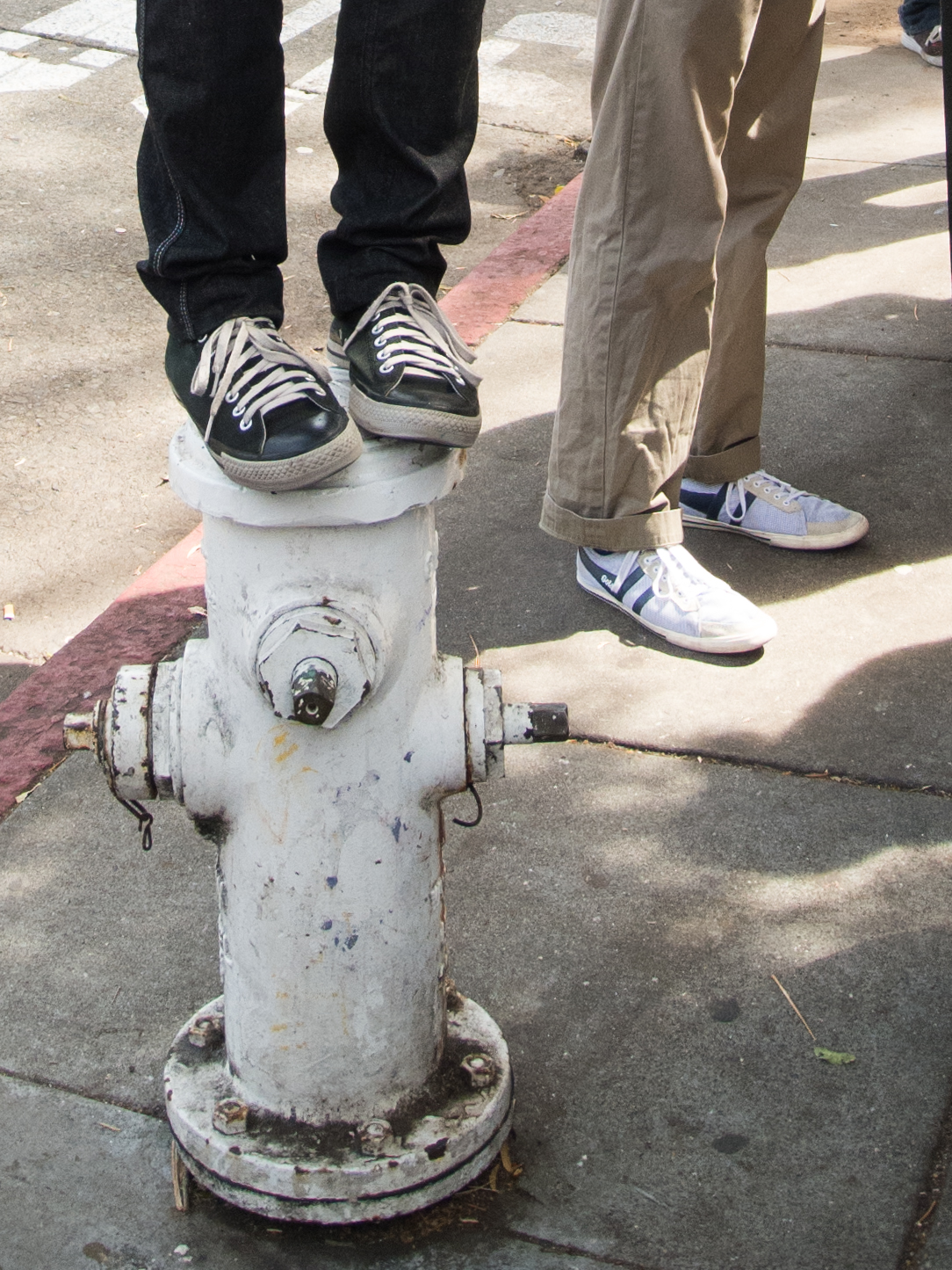 A photographer stands on a fire hydrant to gain a better perspective during a Flickr photowalk on Masonic Avenue at Haight Street in San Francisco, Calif. Saturday, Aug. 24, 2013.