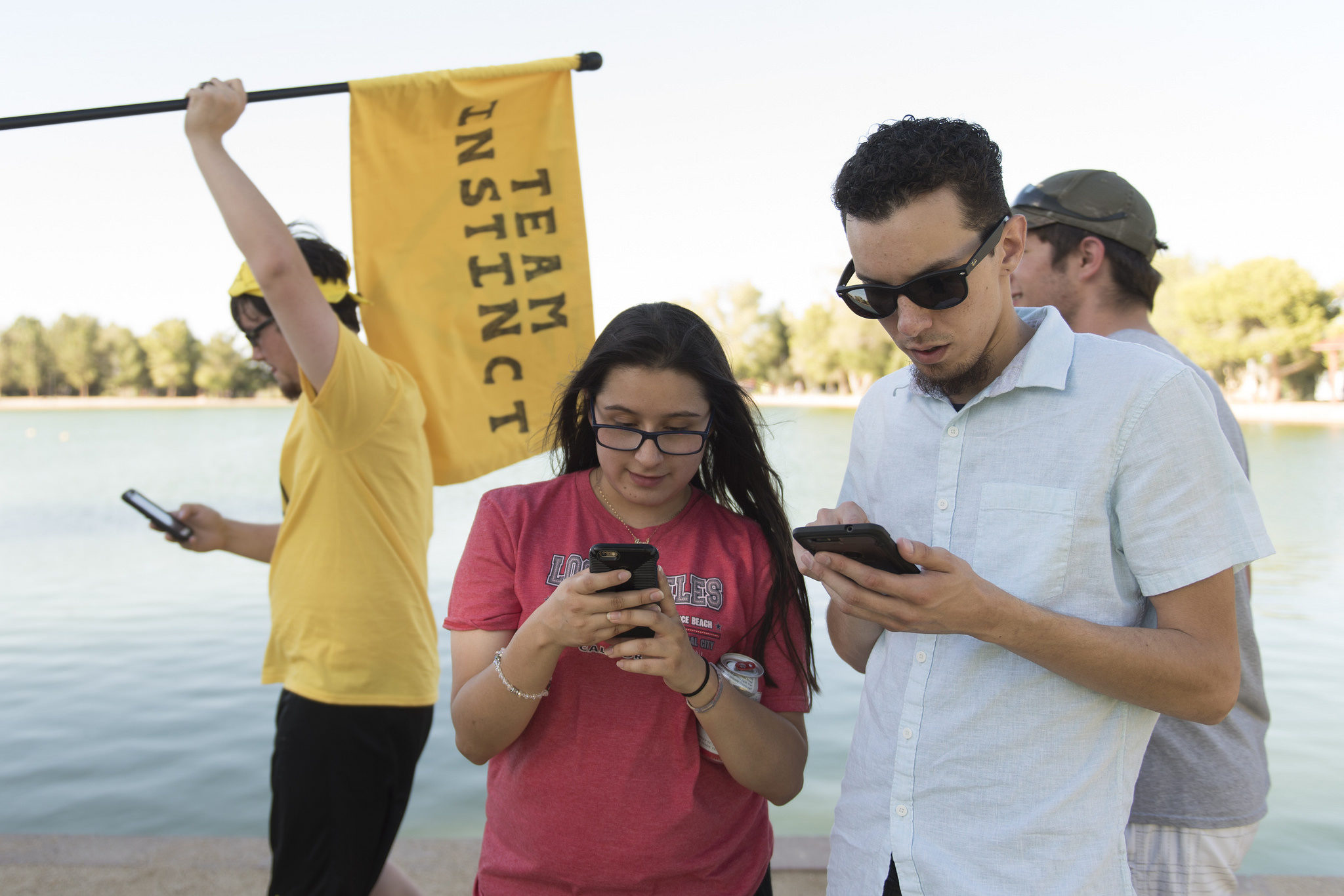 Jennifer Soto, center, and Joao Silva, right, play Pokemon Go at Sunset Park in Las Vegas Sunday, July 10, 2016. Eddy Wojdan of team Instinct waves a flag in the background. More than 2,000 Pokemon Go gamers came to the event. Jason Ogulnik/Las Vegas Review-Journal