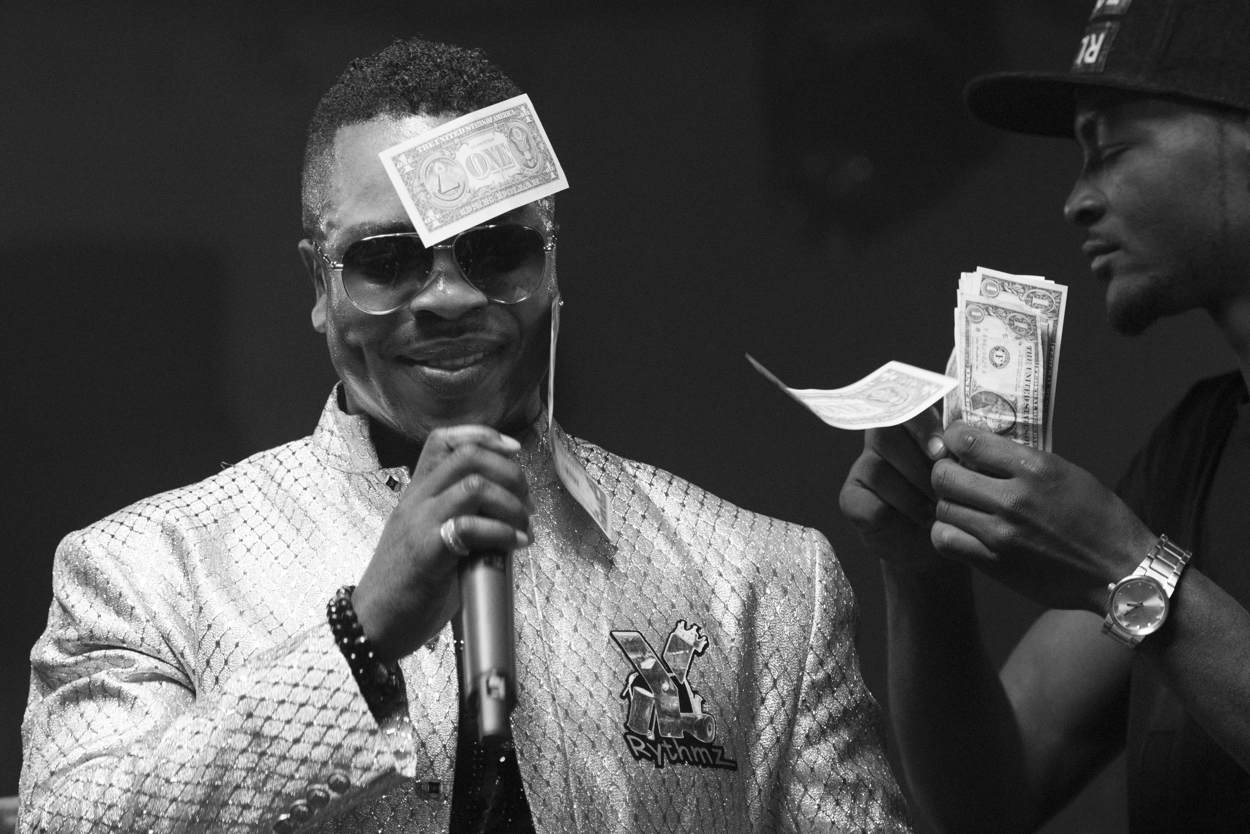 Money sticks to Yinka Rythmz's sweaty forehead as he performs during the I Am Somebody Las Vegas 2.0 show at Mia's Banquet Hall in Las Vegas, Saturday, Dec. 17, 2016.
