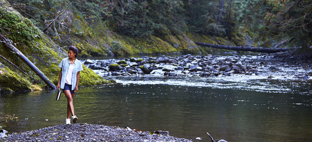 Women wearing activewear walking on river bank in Washington. 