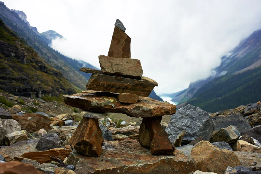 Fog settles in over Lake Louise in Canada; wayfinder found on mountain hiking trail. 