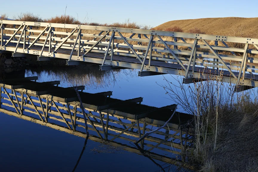 Footbridge reflected in water. 