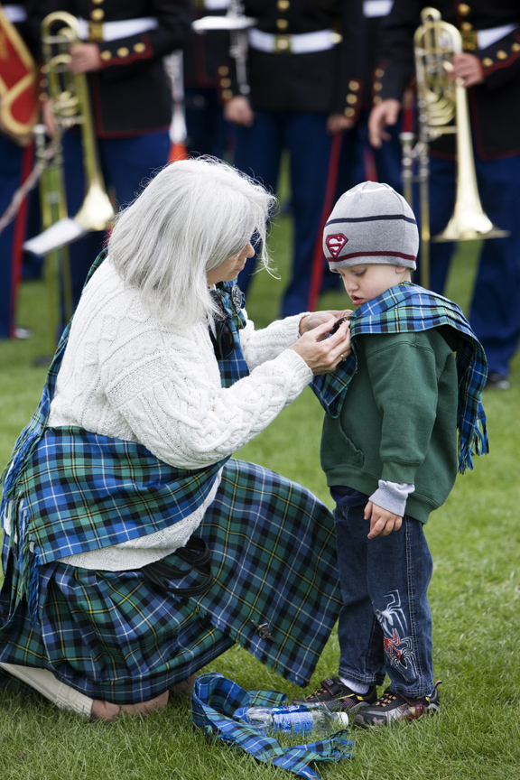 Woman kneels to help youngster at the Highland Festival in Estes Park, Colorado. 