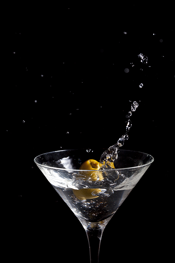 Olive dropping into a martini, with a splash. 