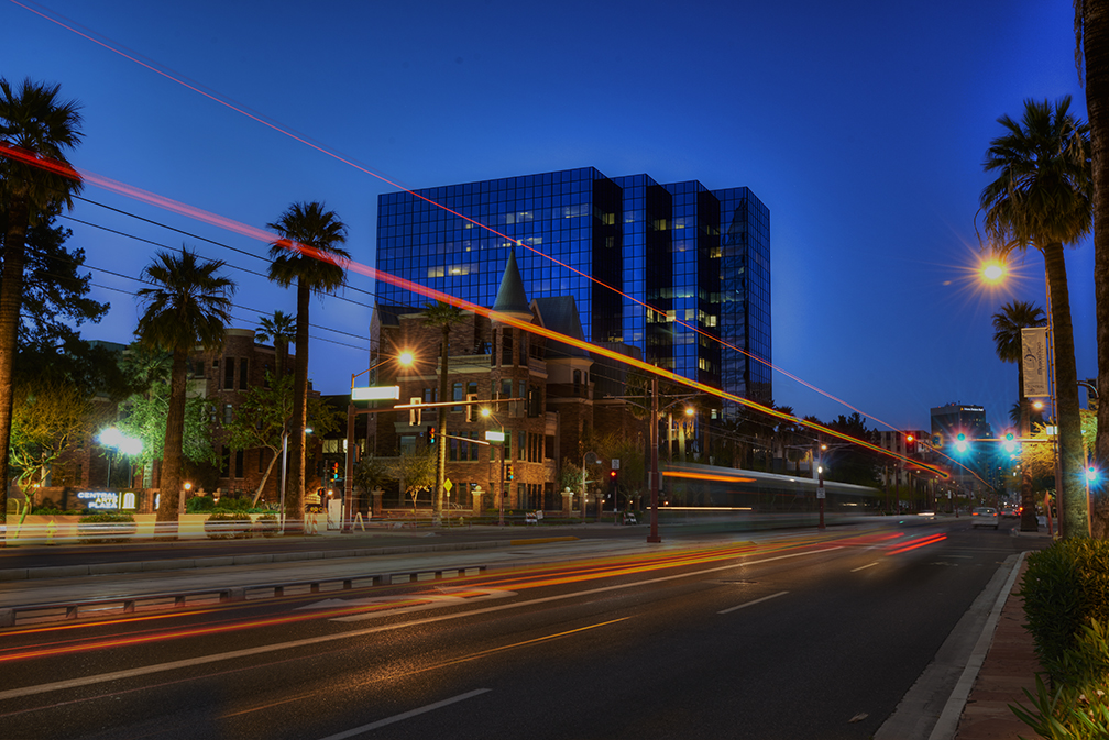 Phoenix commercial buildings at night with traffic light trails. 