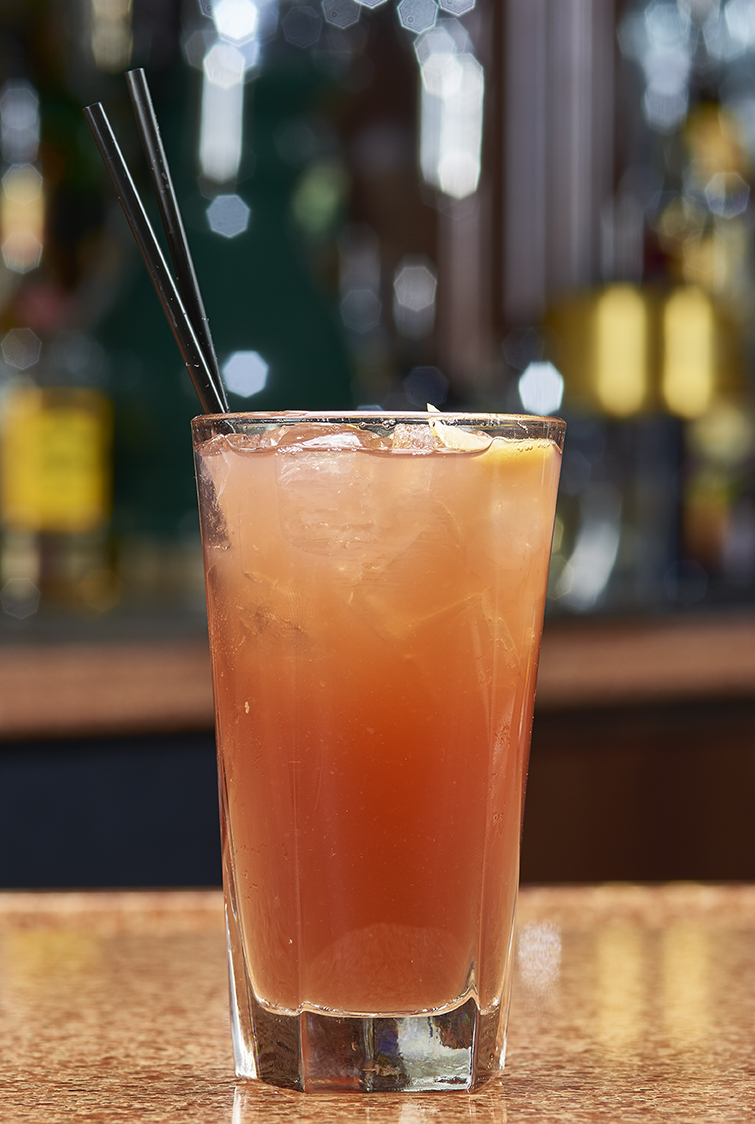 Colorful mixed cocktail in tall glass.