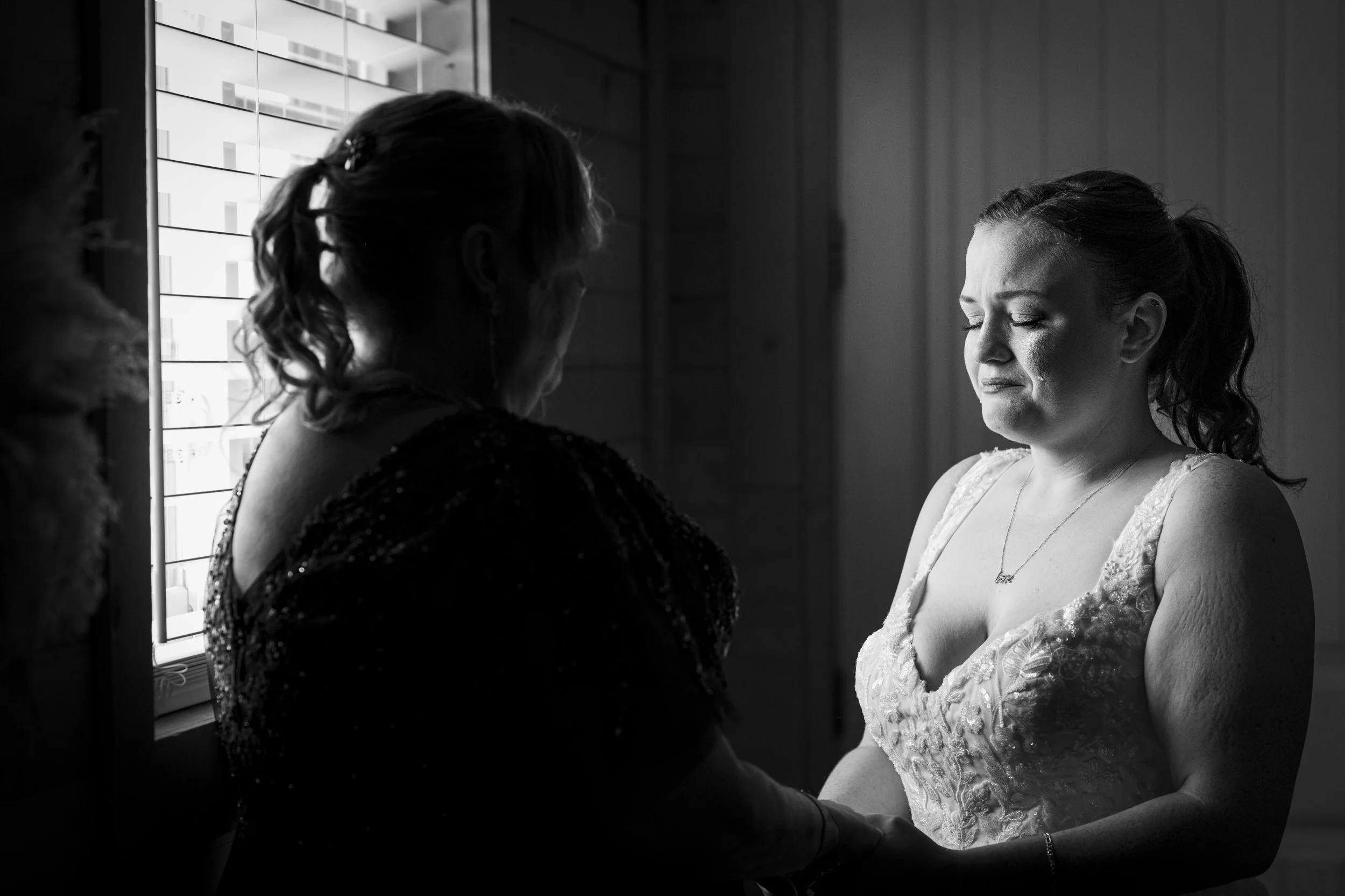 A bride getting emotional and crying with her mom moments before she walks down the aisle black and white photography fisher island South Florida Miami Beach wedding