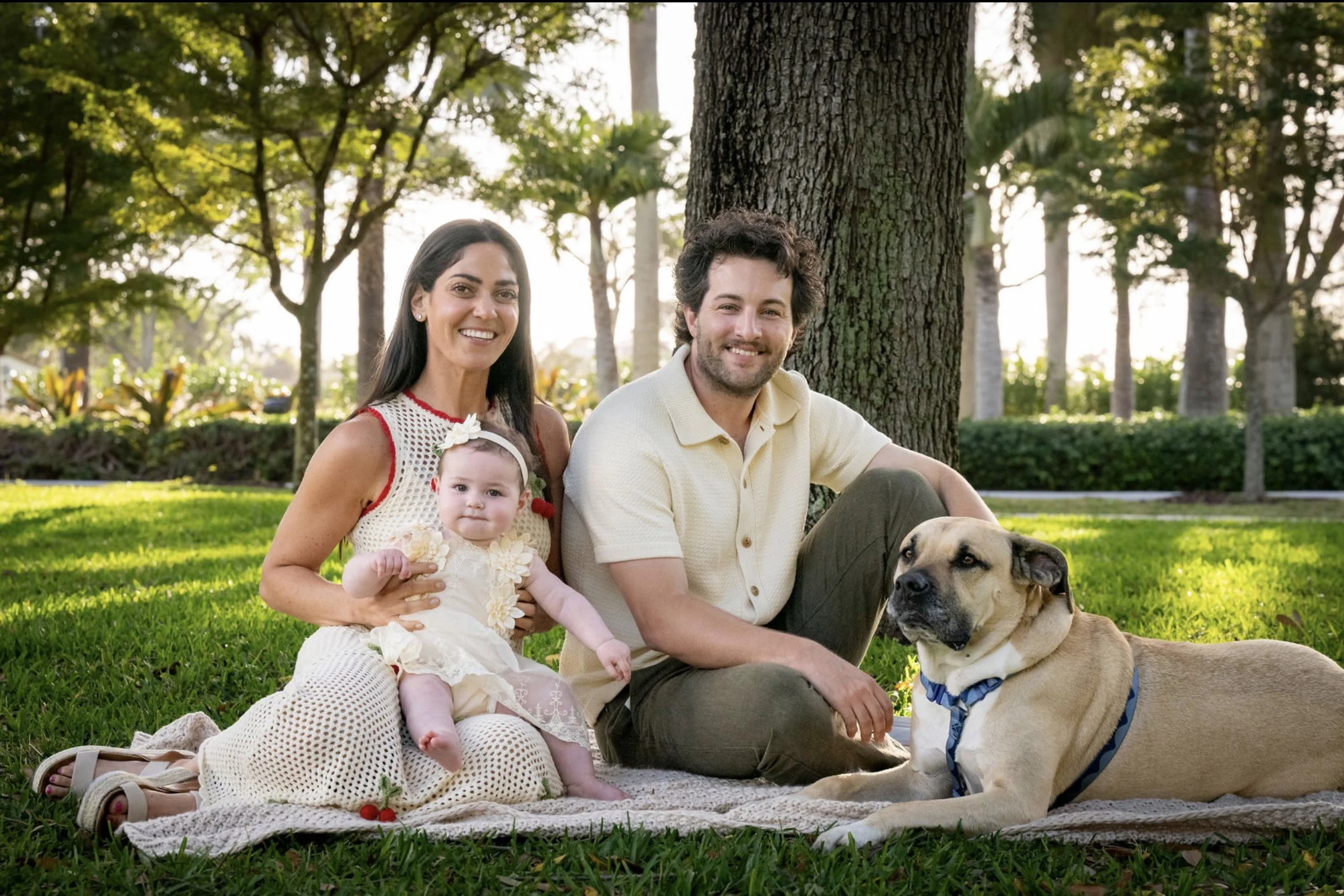 A family session with a baby, mom, dad and the family dog at the park at Fisher Island located in Miami Beach, Florida
