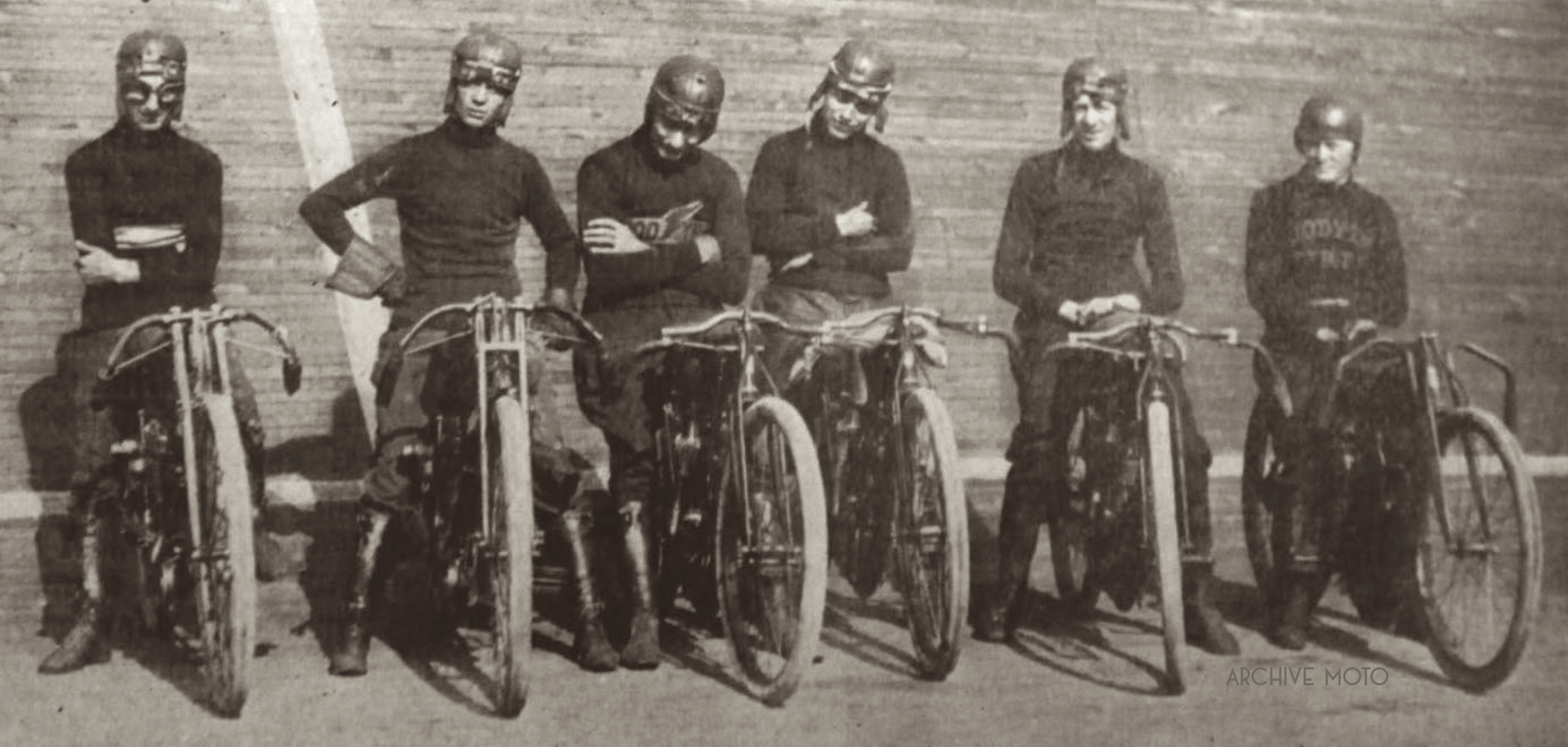 Red Parkhurst is seen here, mounted on an Indian 5th from the left, the track at his back inside the newly constructed Milwaukee Motordrome at the start of the opening season, Summer 1913. Photographed alongside Parkhurst from left to right are Glen Stokes, Jimmy Cox, Eddie Bowen, Danny Armstrong, (Parkhurst), and William Hamilton.