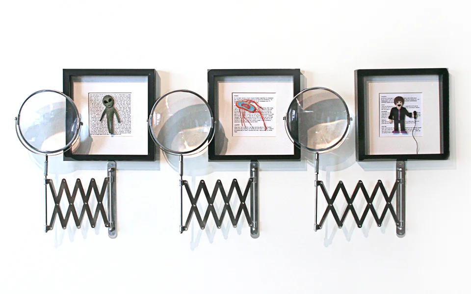   ALIENS: Conspiracy Theory Obsession  Mixed Media, felt, embroidery thread, laser print, plastic magnifying lens, mirror frame Background text sourced from “Turk184” post on Conspiracy Theories and Hoaxes   E-COLI BACTERIA: Obsessive Compulsive Diso