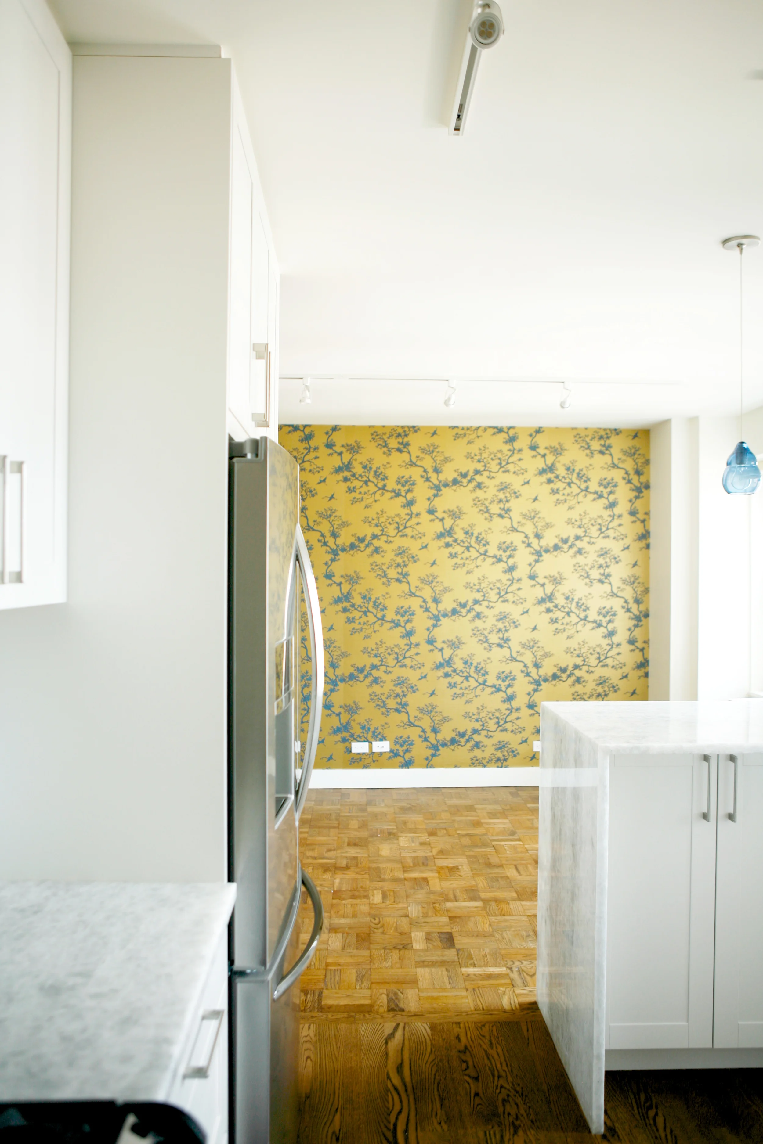 Love the contrast of the white kitchen and the gold wallpaper.