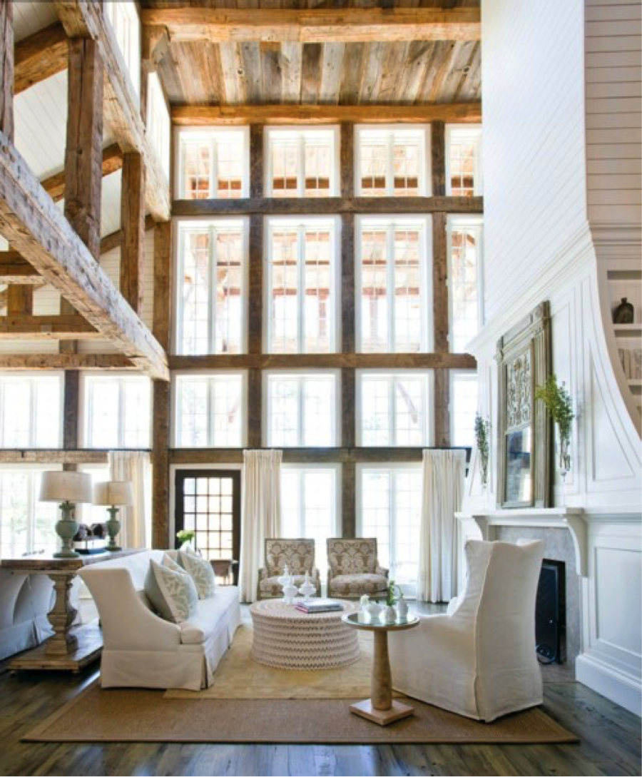 Beautiful rustic house- Tempering an all-white palette with natural wood and stone. Notice the black door, fire screen and other small details that ground the room. We often think that rustic has to be brown and dark. Nothing could be farther from the truth.