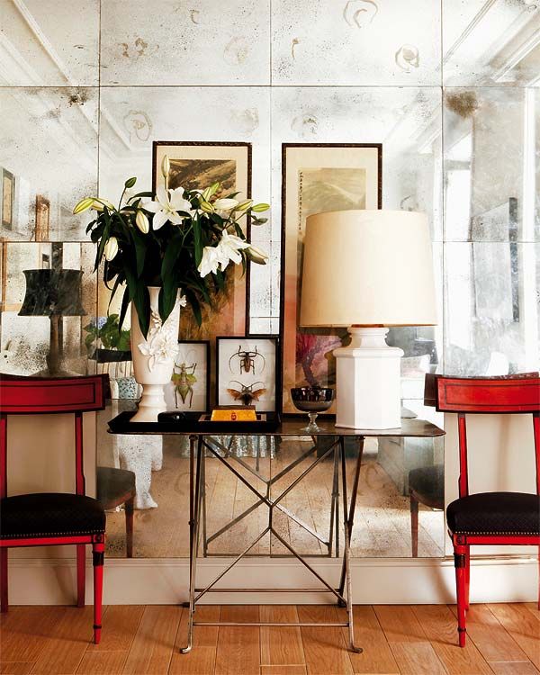 Antique mirror helps make a space look sophisticated and collected. Love the red chairs against the silvery mirrors. The circle effect in the antique mirror is the true way a mirror would silver and age with time.