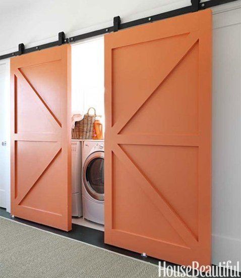 Always a fan of barn doors. These really make a statement when they are painted orange against a white wall. Who knew a laundry nook could be so cute?