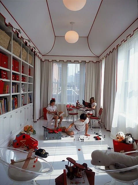 Circus tent inspired room. Love the idea of keeping the room open for play and storing books and toys in the cabinet. Notice the modern lights with the more traditional detailing on the white ceiling tent. What a functional yet whimsical look. Oh, and look... all of the kids are dressed in white. ;)