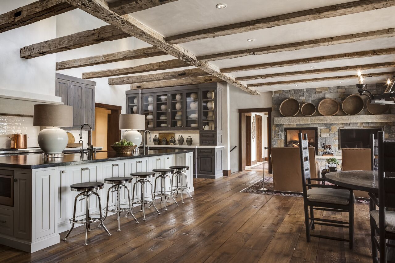 Squaring off the cabinetry and keeping it simple and understated contrasts the rustic nature of the wooden beams and flooring. A collection of White Pottery in the kitchen hutch keeps the space clean and modern.